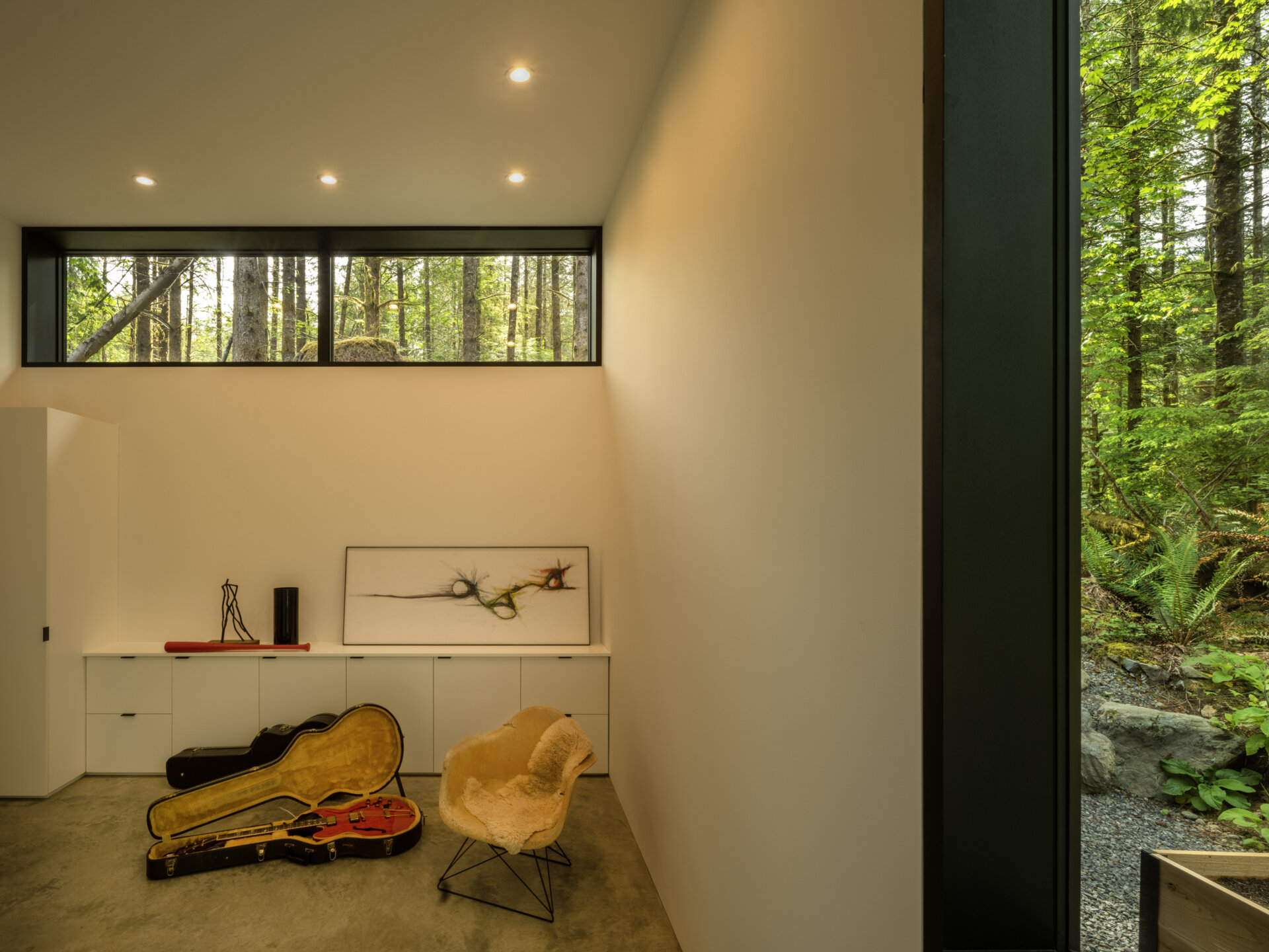 Tall windows bring in steady natural light, illuminating the polished concrete floors and pale walls of the music room.