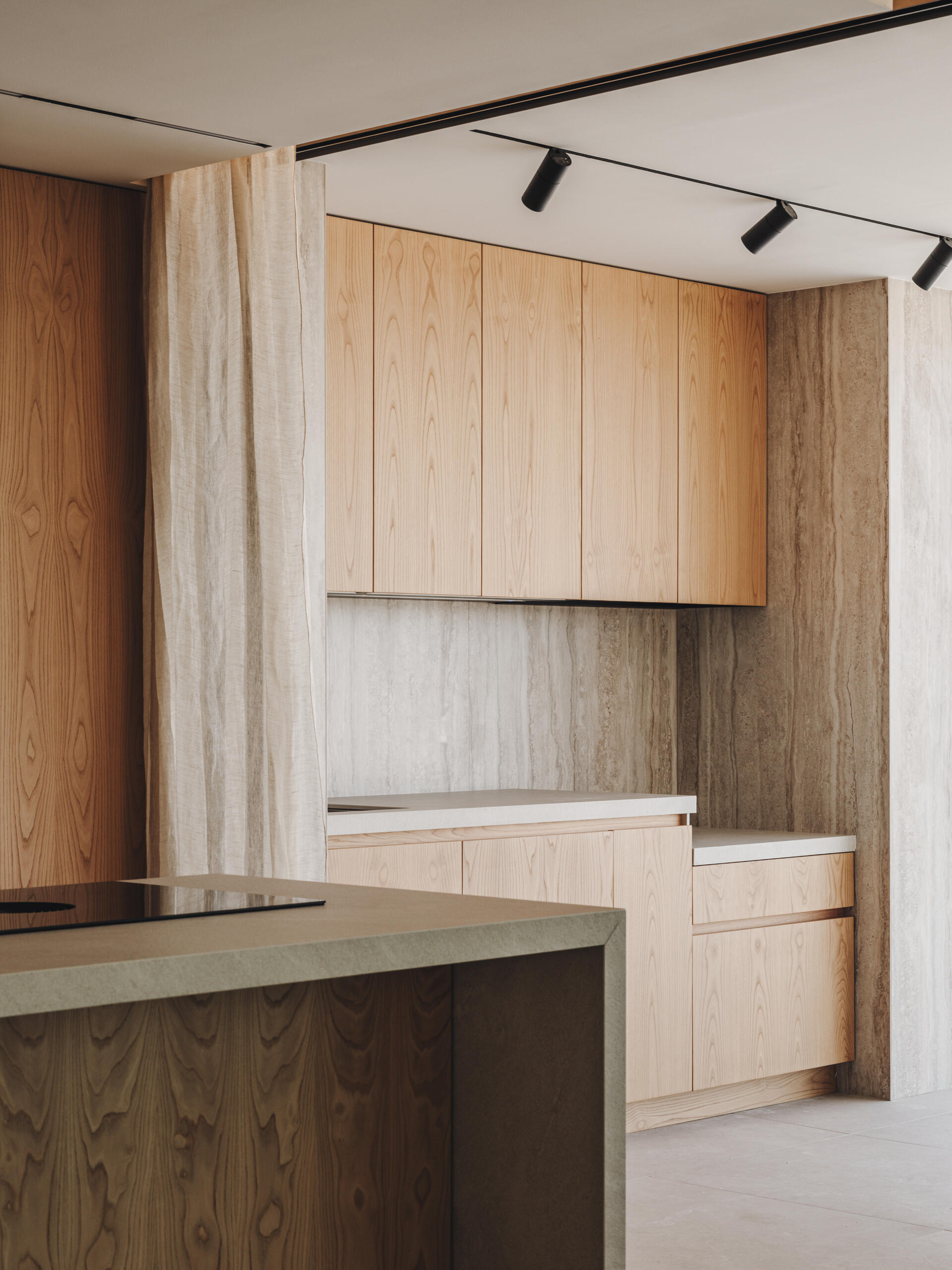 Custom oak cabinetry, integrated lighting, and matching indoor-outdoor finishes define this refined, functional kitchen.