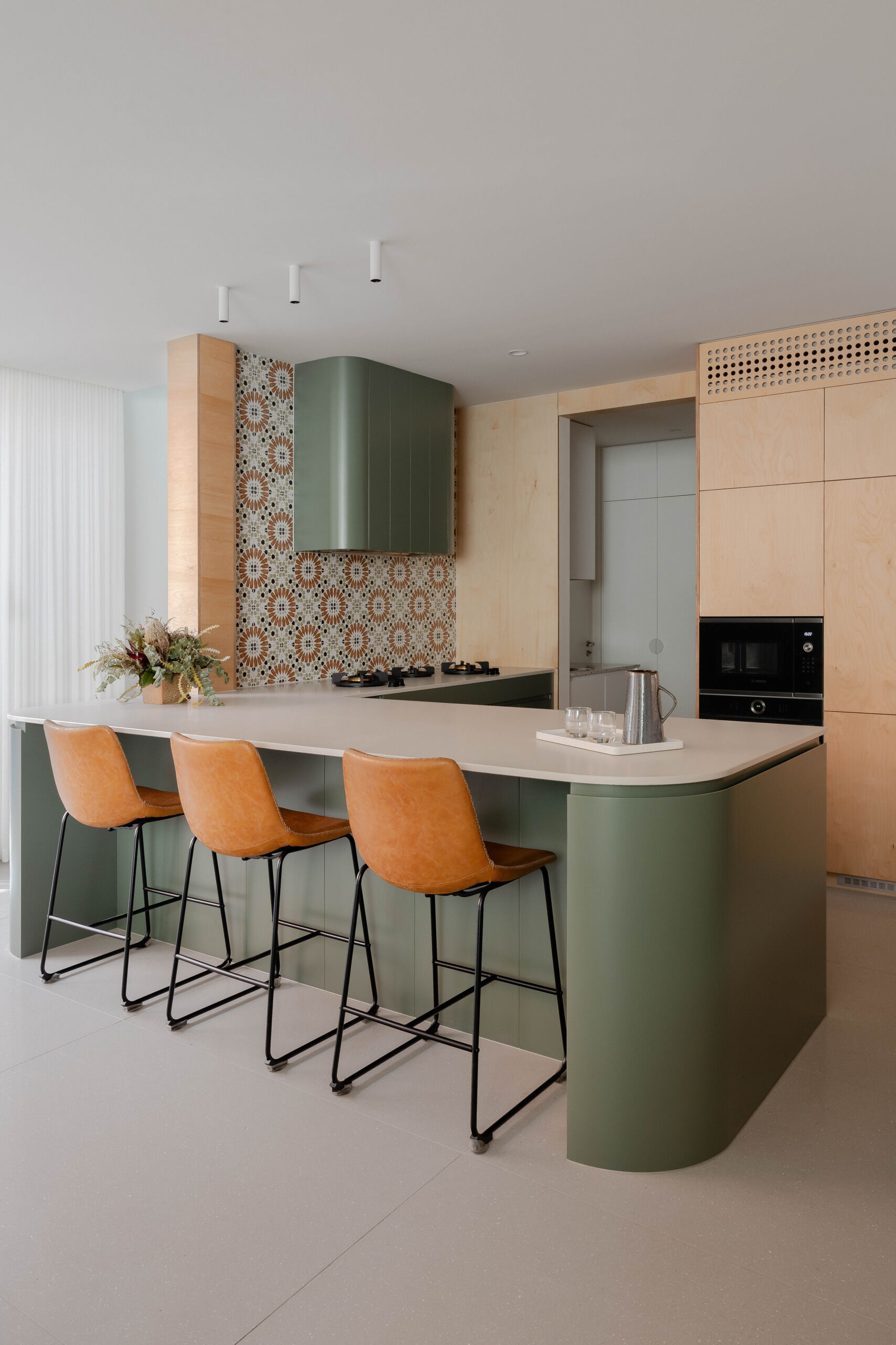 With green and wood joinery, the kitchen and dining area continue the home’s natural material palette. These spaces are active and expressive, balancing the energy of daily meals with a calm, tonal foundation. Large openings connect directly to the courtyard, allowing light and breeze to fill the space.