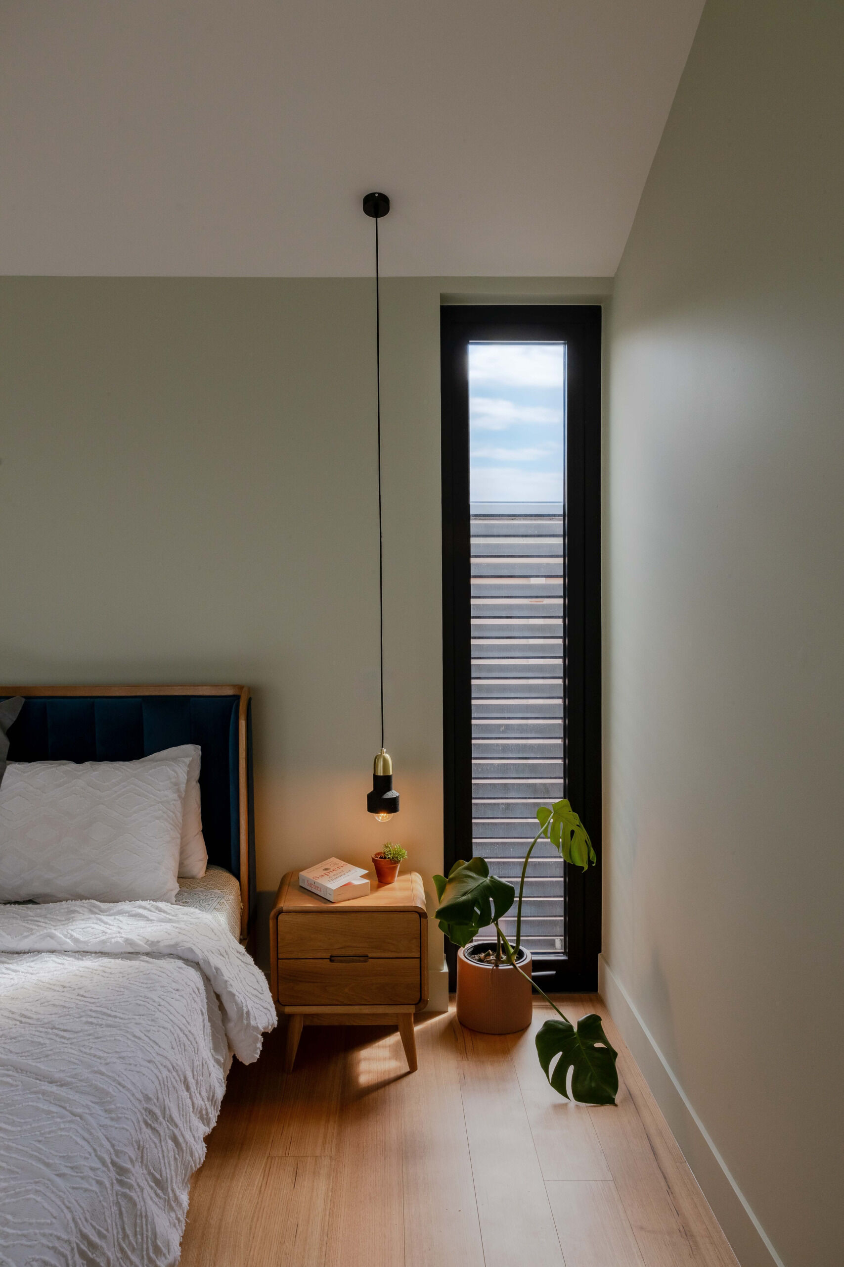 Positioned for privacy and outlook, the primary bedroom for the parents, is a restful space with leafy views. Its palette is subdued but warm, echoing the natural tones found throughout the rest of the home. A built-in bench runs along the window, offering a quiet place to pause. Every detail has been considered to promote calm and comfort.