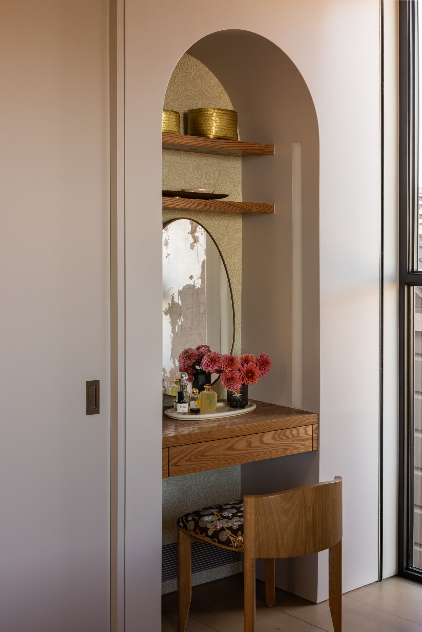 A built-in vanity wrapped in Zak & Fox wallcoverings is paired with a sculptural Nickey Kehoe stool. It’s a quiet, elegant detail that blends seamlessly into the room’s overall calm and refined atmosphere.