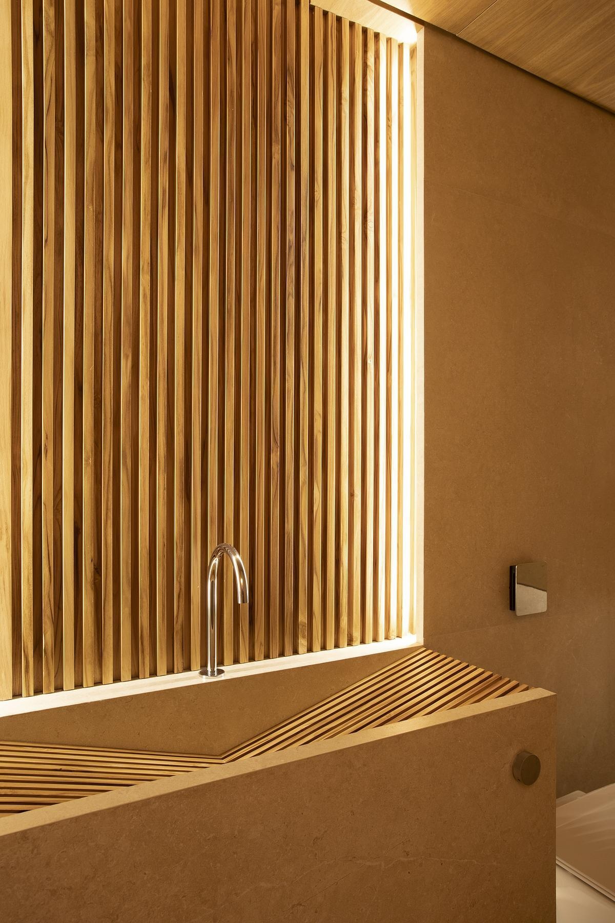 A serene tub set in warm teak and pale porcelain brings spa-like calm to the bathroom, with a smart layout that maximizes both space and style.