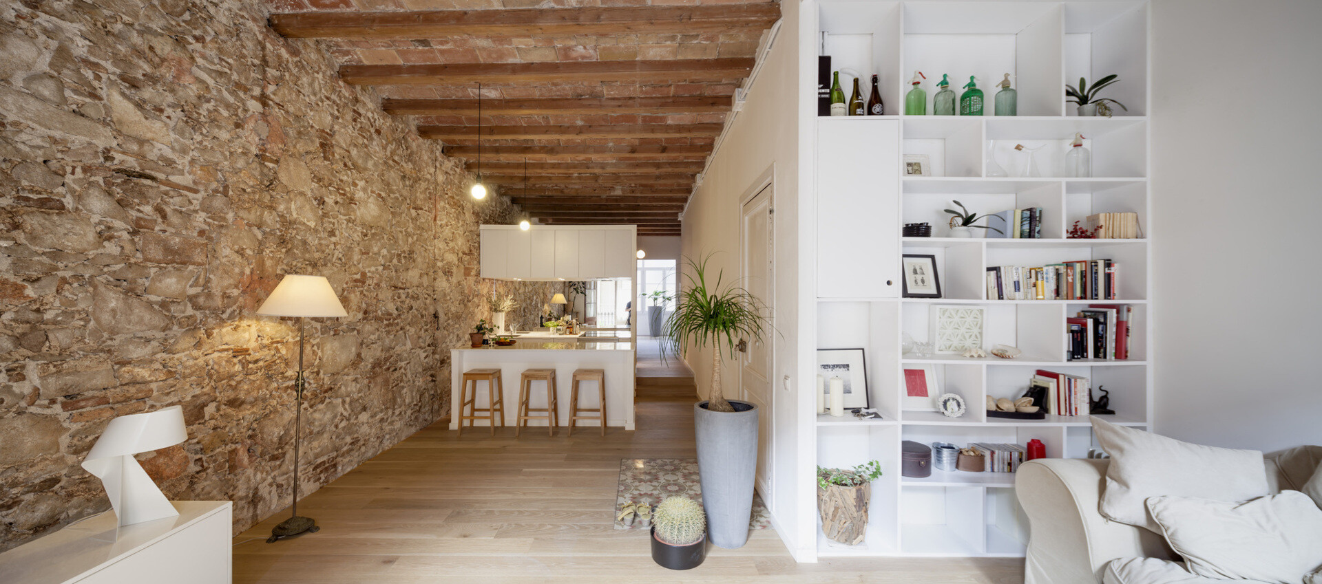 A serene, Japanese-inspired Barcelona apartment that blends stone walls, natural oak, soft light, and open-plan living.