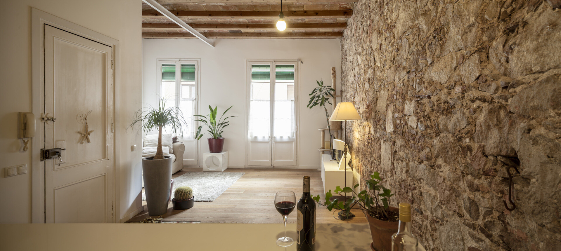 A serene, Japanese-inspired Barcelona apartment that blends stone walls, natural oak, soft light, and open-plan living.