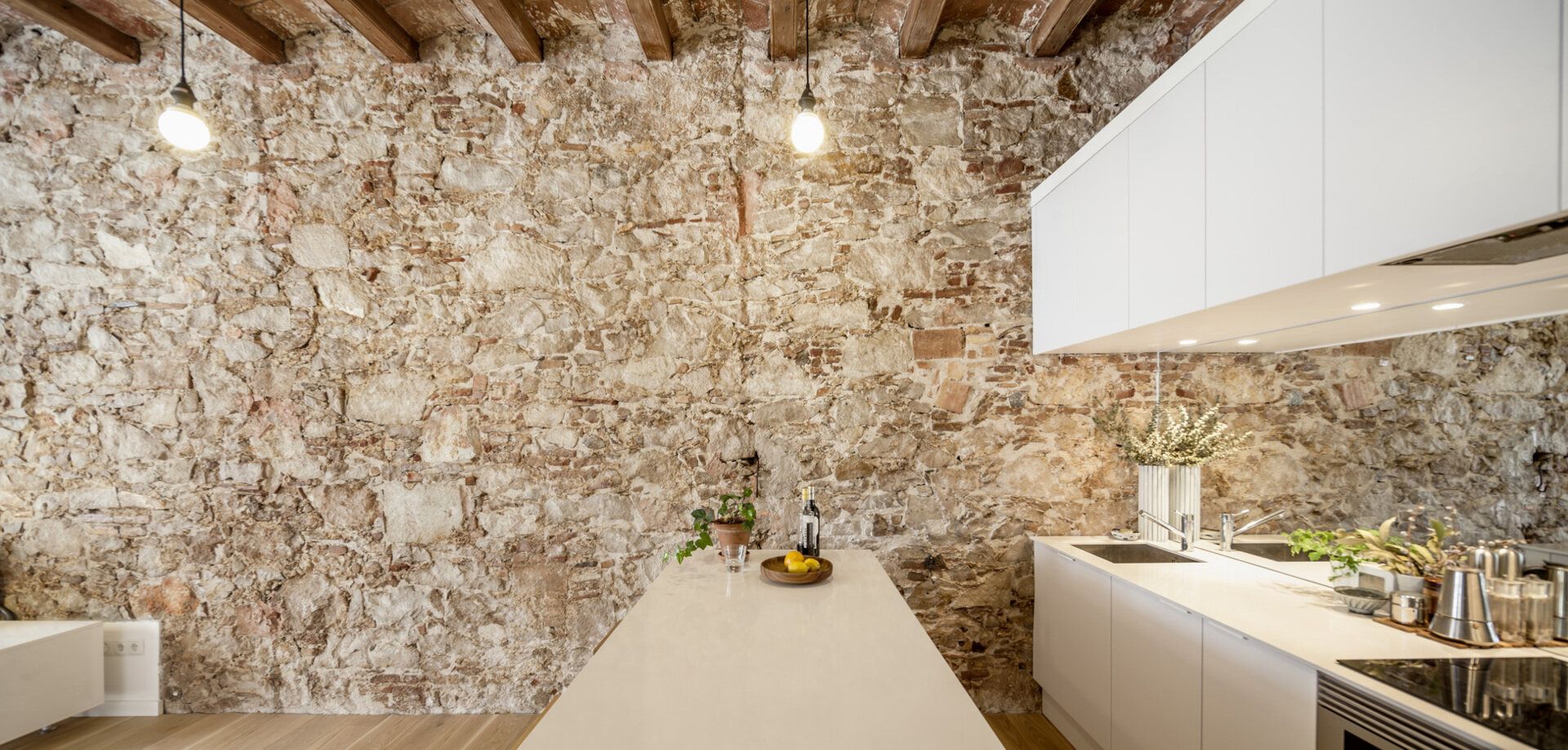A serene, Japanese-inspired Barcelona apartment that blends stone walls, natural oak, soft light, and open-plan living.