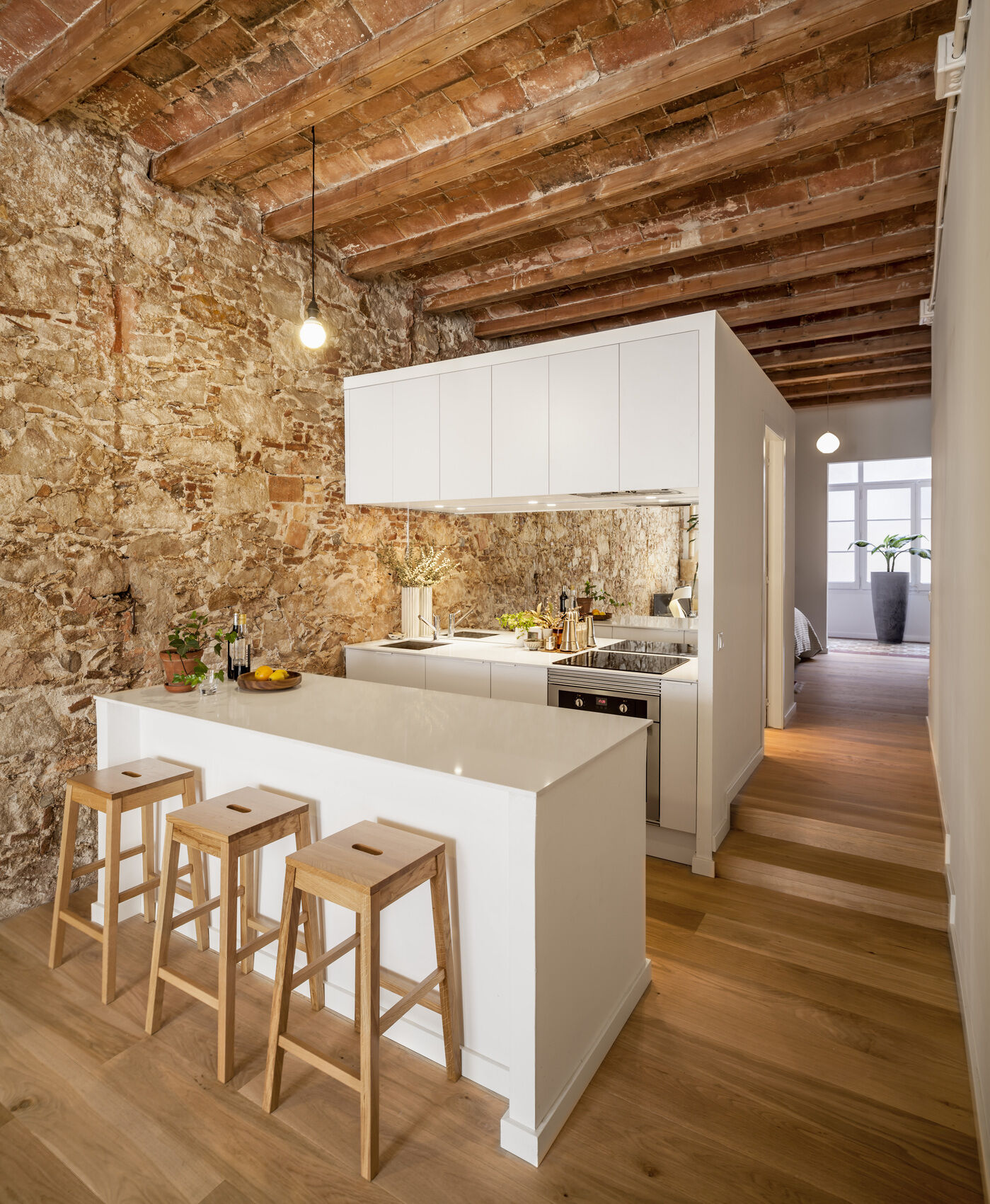 A serene, Japanese-inspired Barcelona apartment that blends stone walls, natural oak, soft light, and open-plan living.