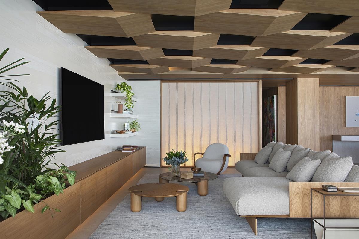 This geometric wood ceiling in an open plan interior transforms structural necessity into a standout design feature, blending texture with hidden functionality.
