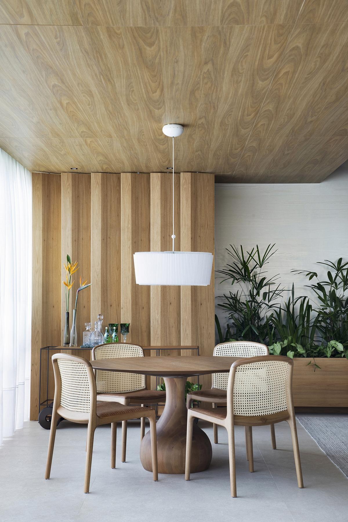 This geometric wood ceiling in an open plan apartment interior transforms structural necessity into a standout design feature, blending texture with hidden functionality.