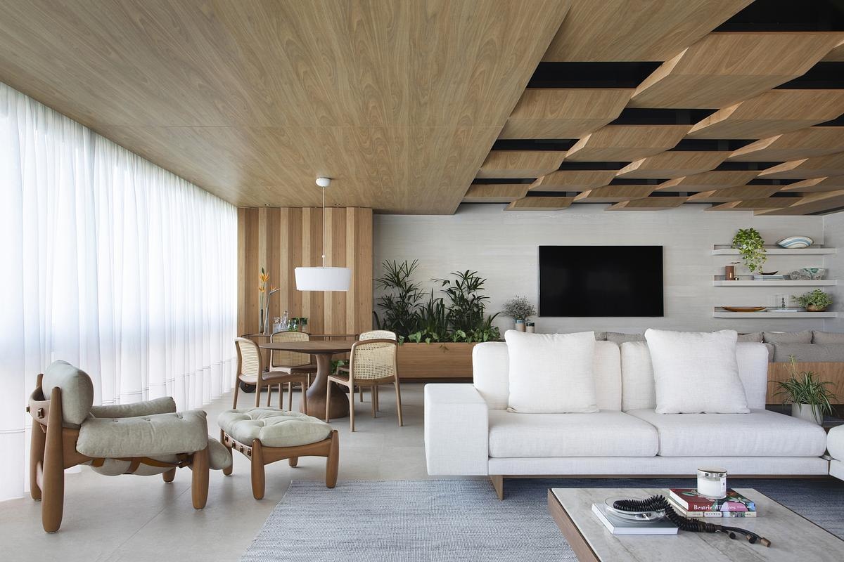 This geometric wood ceiling in an open plan apartment interior transforms structural necessity into a standout design feature, blending texture with hidden functionality.