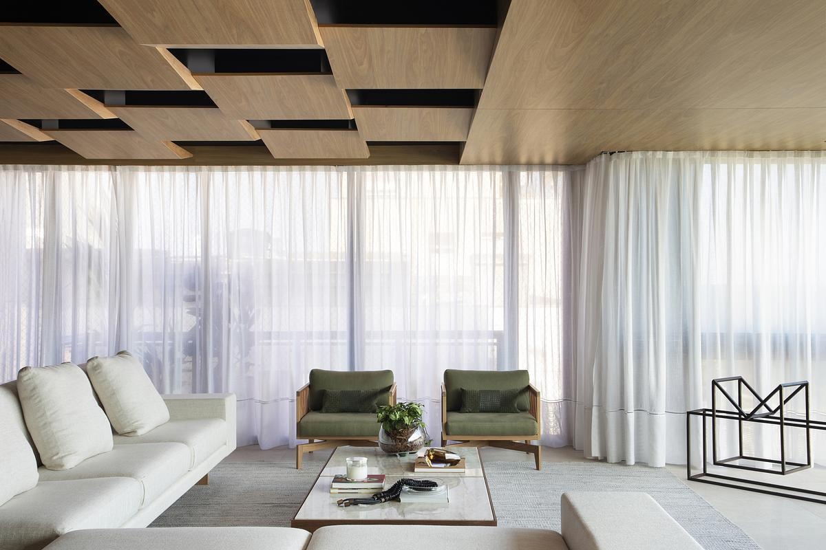 This geometric wood ceiling in an open plan apartment interior transforms structural necessity into a standout design feature, blending texture with hidden functionality.