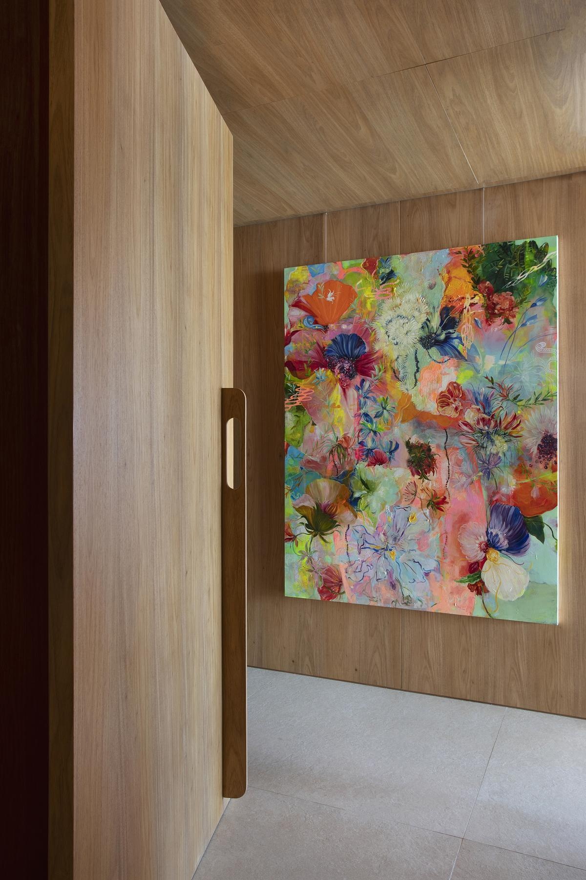 Wood-paneled gallery walls display contemporary Brazilian art, using a discreet hanging system that keeps the design flexible and uninterrupted.