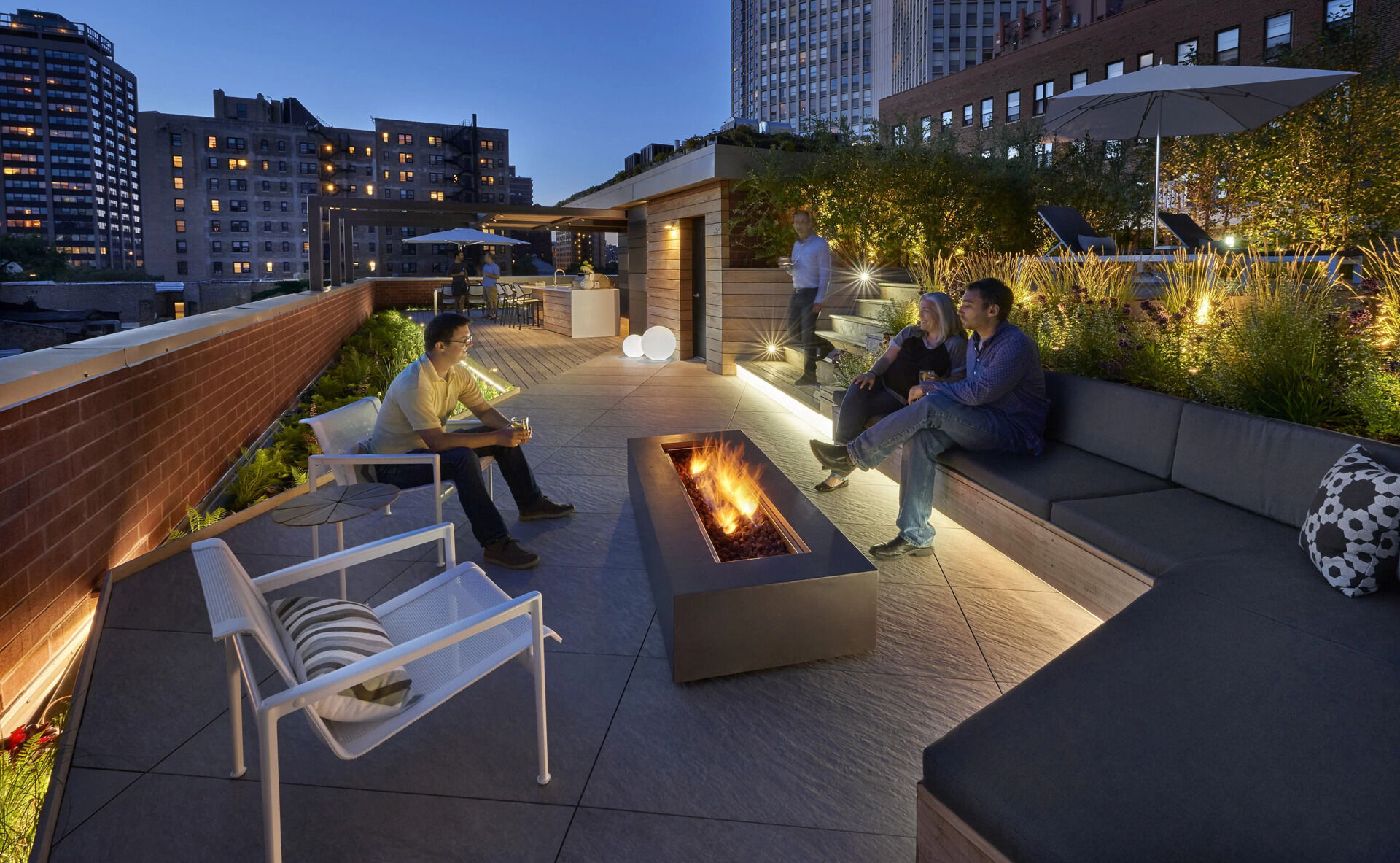 Terraced hardwood steps and porcelain tile define outdoor rooms in this rooftop retreat, creating the feel of a private yard high above the city.
