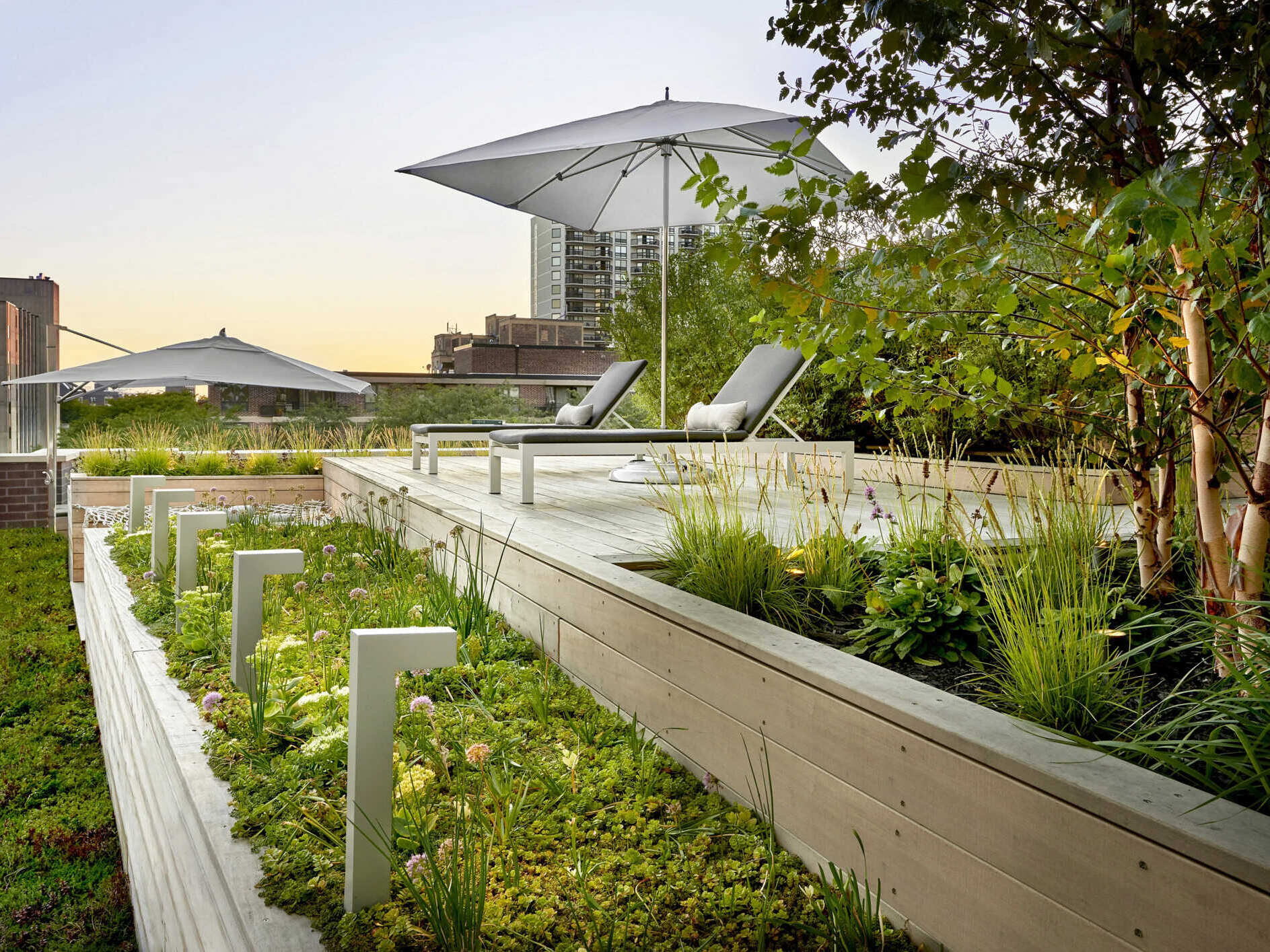 Terraced hardwood steps and porcelain tile define outdoor rooms in this rooftop retreat, creating the feel of a private yard high above the city.