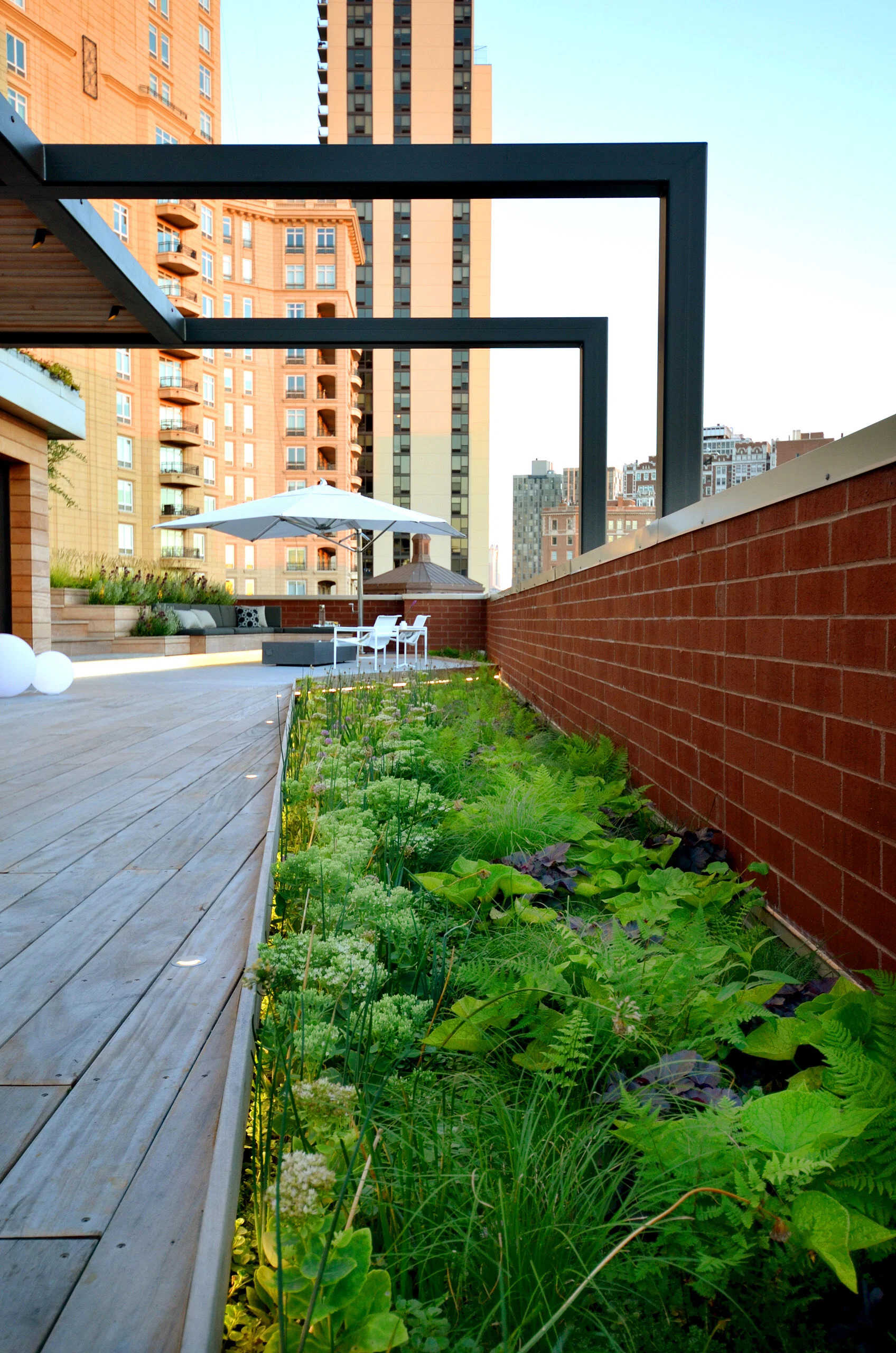 Terraced hardwood steps and porcelain tile define outdoor rooms in this rooftop retreat, creating the feel of a private yard high above the city.