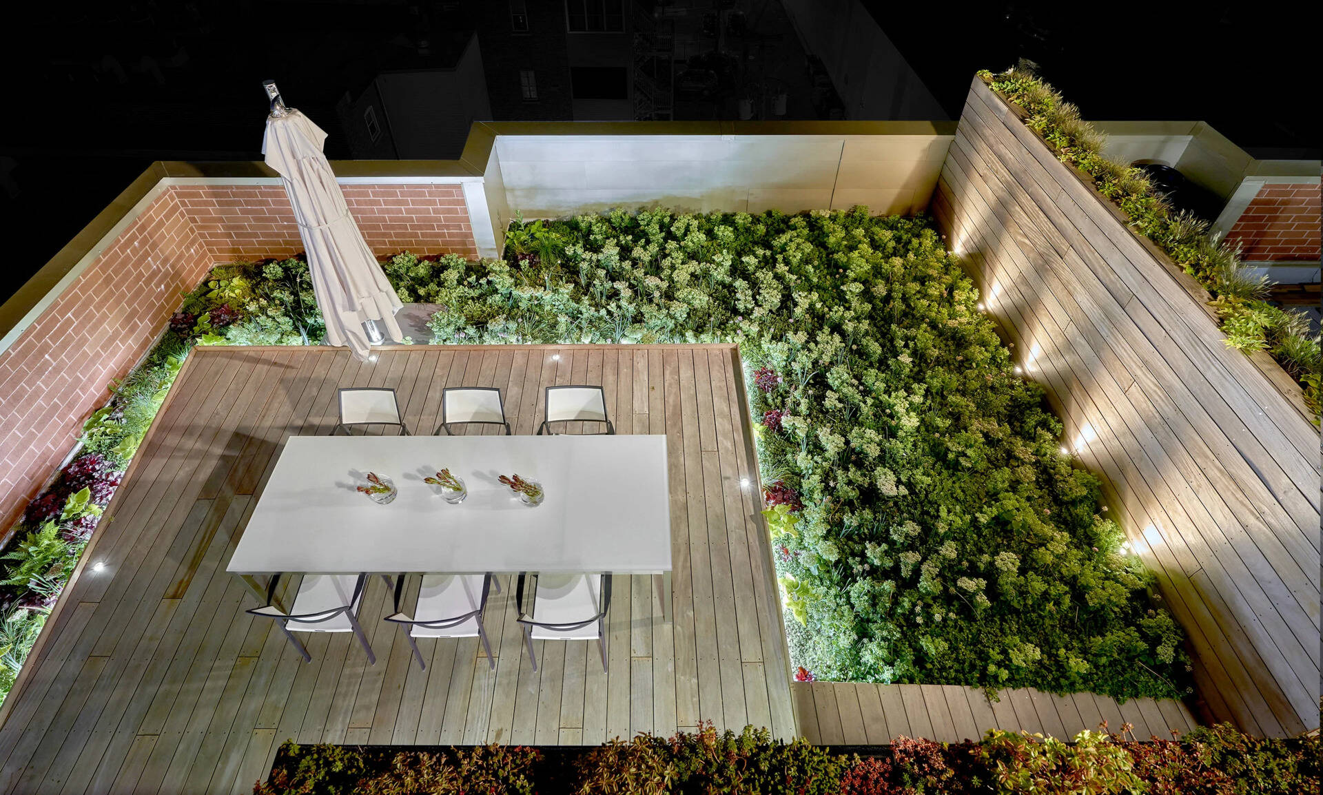 Terraced hardwood steps and porcelain tile define outdoor rooms in this rooftop retreat, creating the feel of a private yard high above the city.