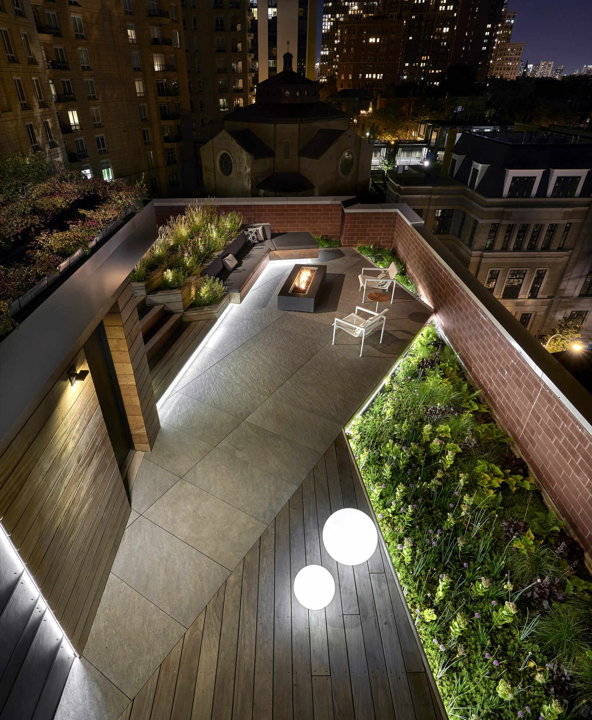 Terraced hardwood steps and porcelain tile define outdoor rooms in this rooftop retreat, creating the feel of a private yard high above the city.