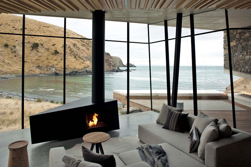 Wrapped in horizontal macrocarpa wood, the living space opens to sweeping views through low-e glass. Earthquake-resistant steel frames keep the space secure without blocking the horizon.