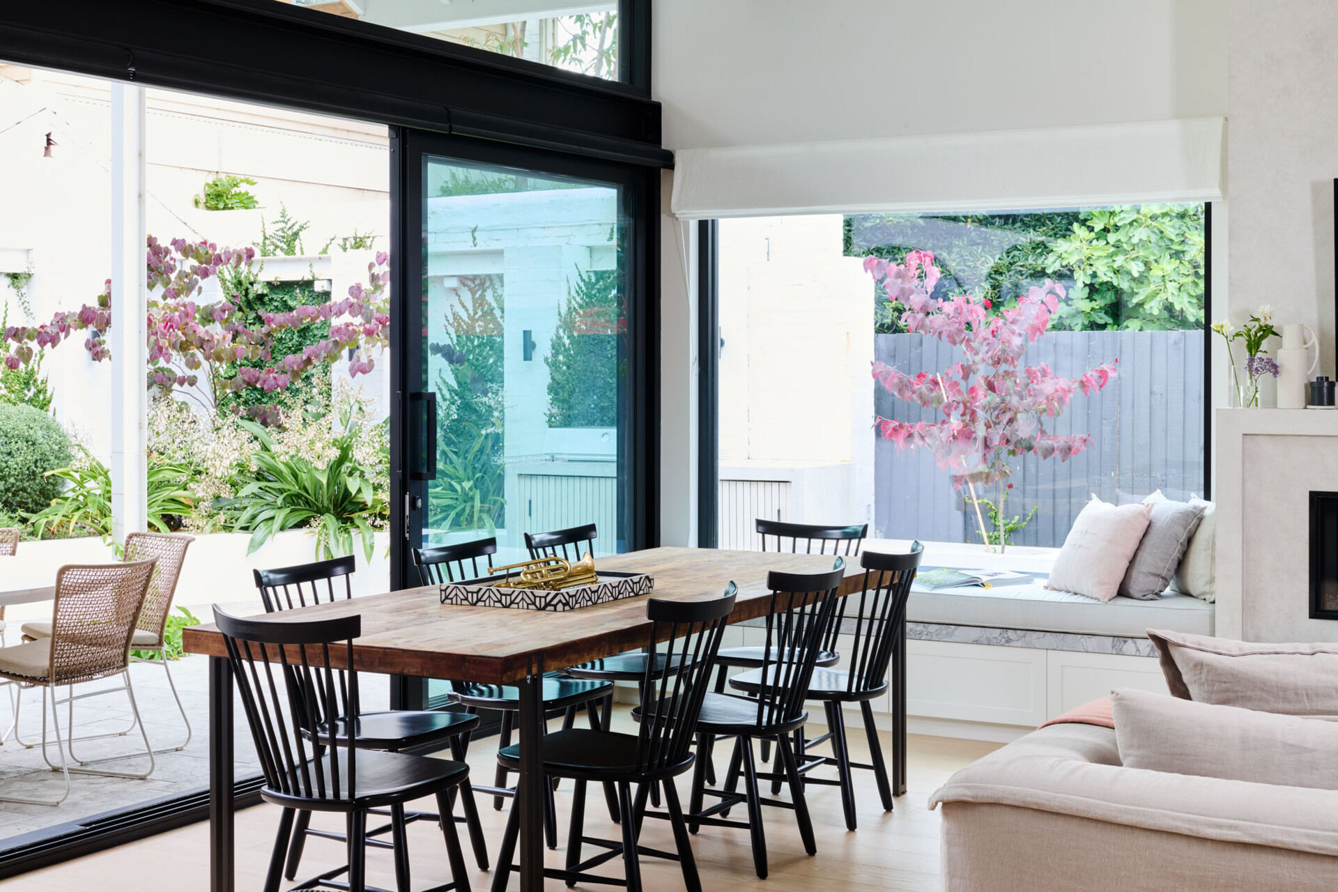 Vaulted ceilings and sliding doors flood this dining area with light. Natural timber furniture and a restrained palette make every meal feel like a retreat.