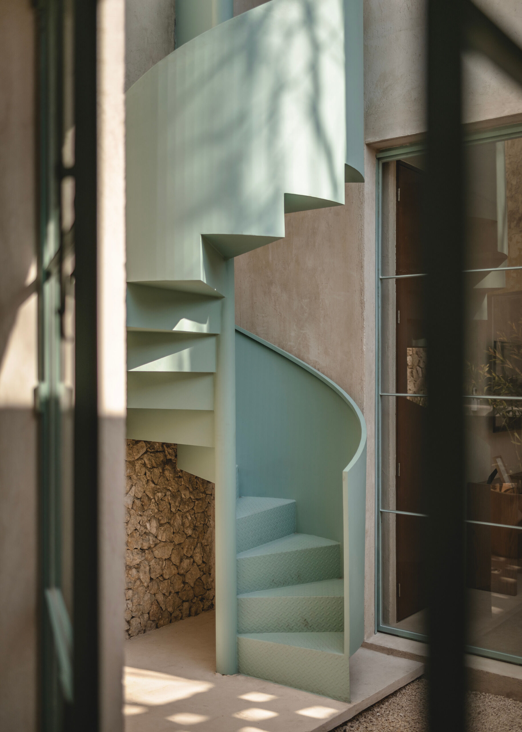 A sculptural spiral staircase tucked within one of the modules connects the different levels of the home. It offers more than just vertical circulation, it becomes a visual element that adds movement and softness to the architectural composition. The curve echoes other design gestures throughout the project, reinforcing the theme of fluid transitions.