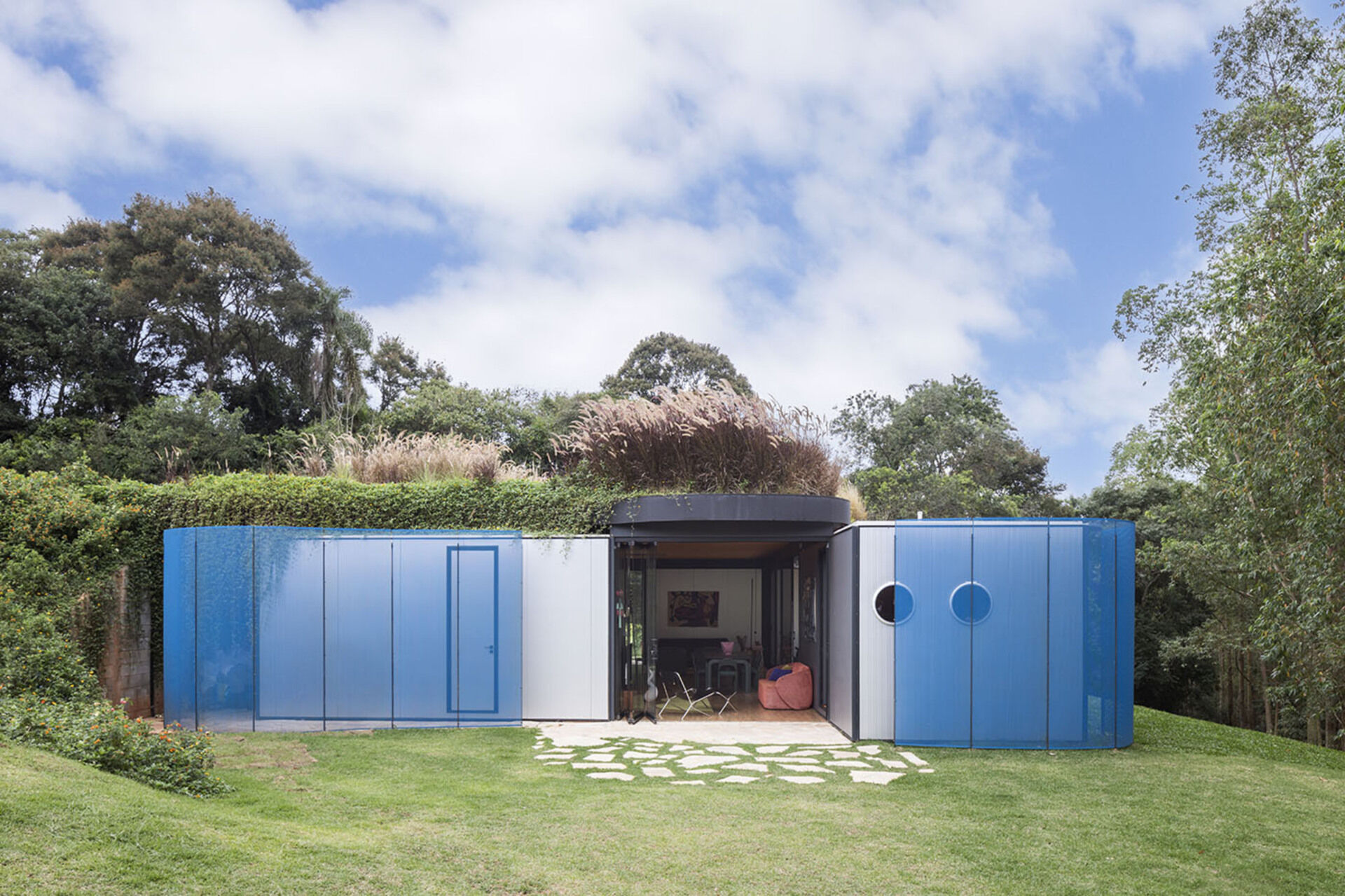 Wrapped in sky-blue steel and softened with curved walls, this prefabricated home hides its modular roots. Rodrigo Ohtake’s clever use of industrial materials brings surprising warmth and elegance.
