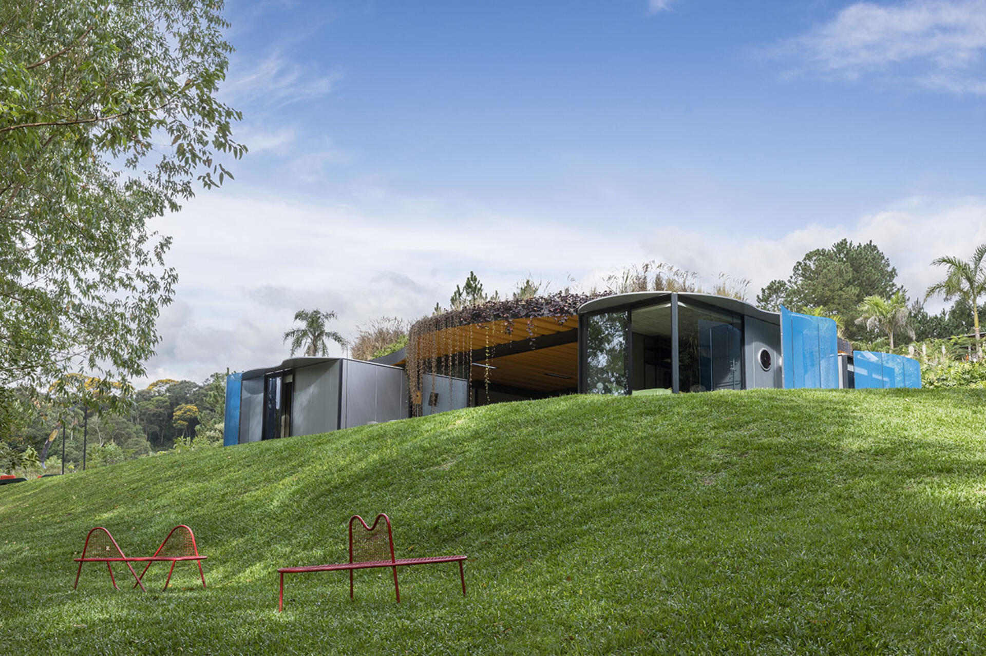 Wrapped in sky-blue steel and softened with curved walls, this prefabricated home hides its modular roots. Rodrigo Ohtake’s clever use of industrial materials brings surprising warmth and elegance.