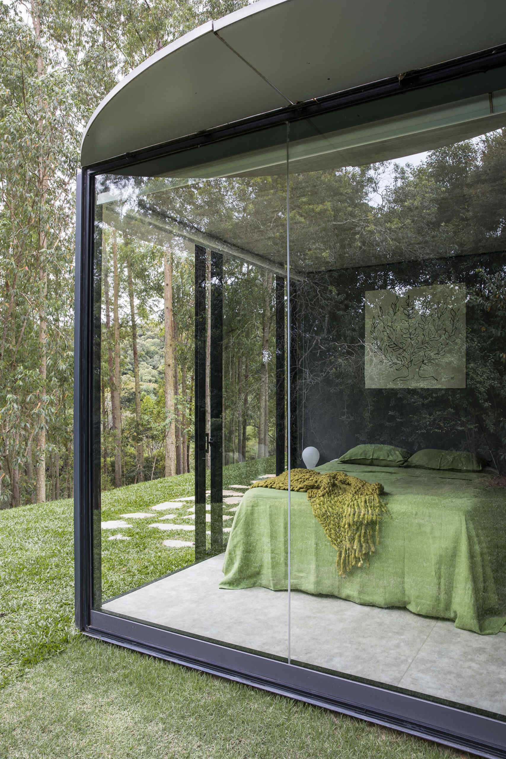 Private bedroom modules feature curved steel screens for privacy and soft morning light. Curtainless windows offer uninterrupted views of nature.