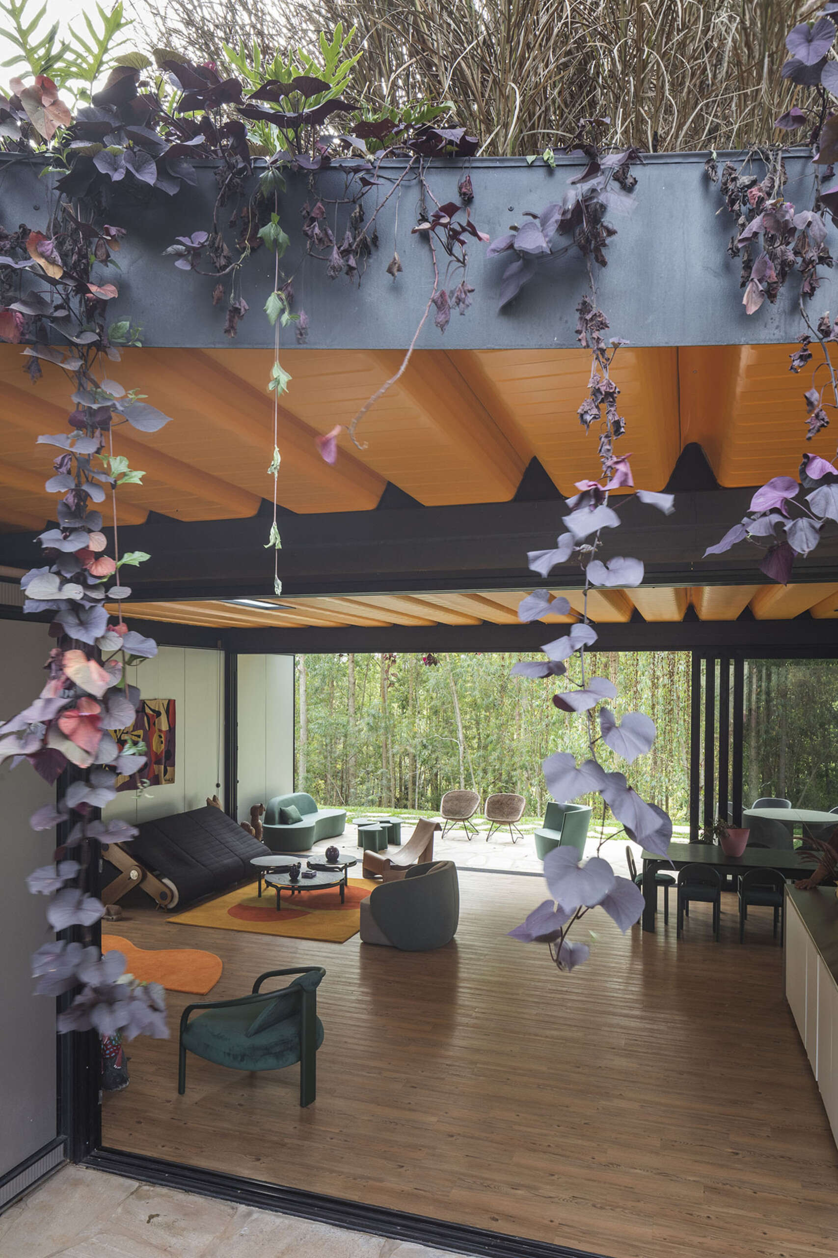 Orange accents, custom furniture, and curtainless windows define the interiors of this joyful weekend home. Everything is designed to feel open, natural, and full of life.