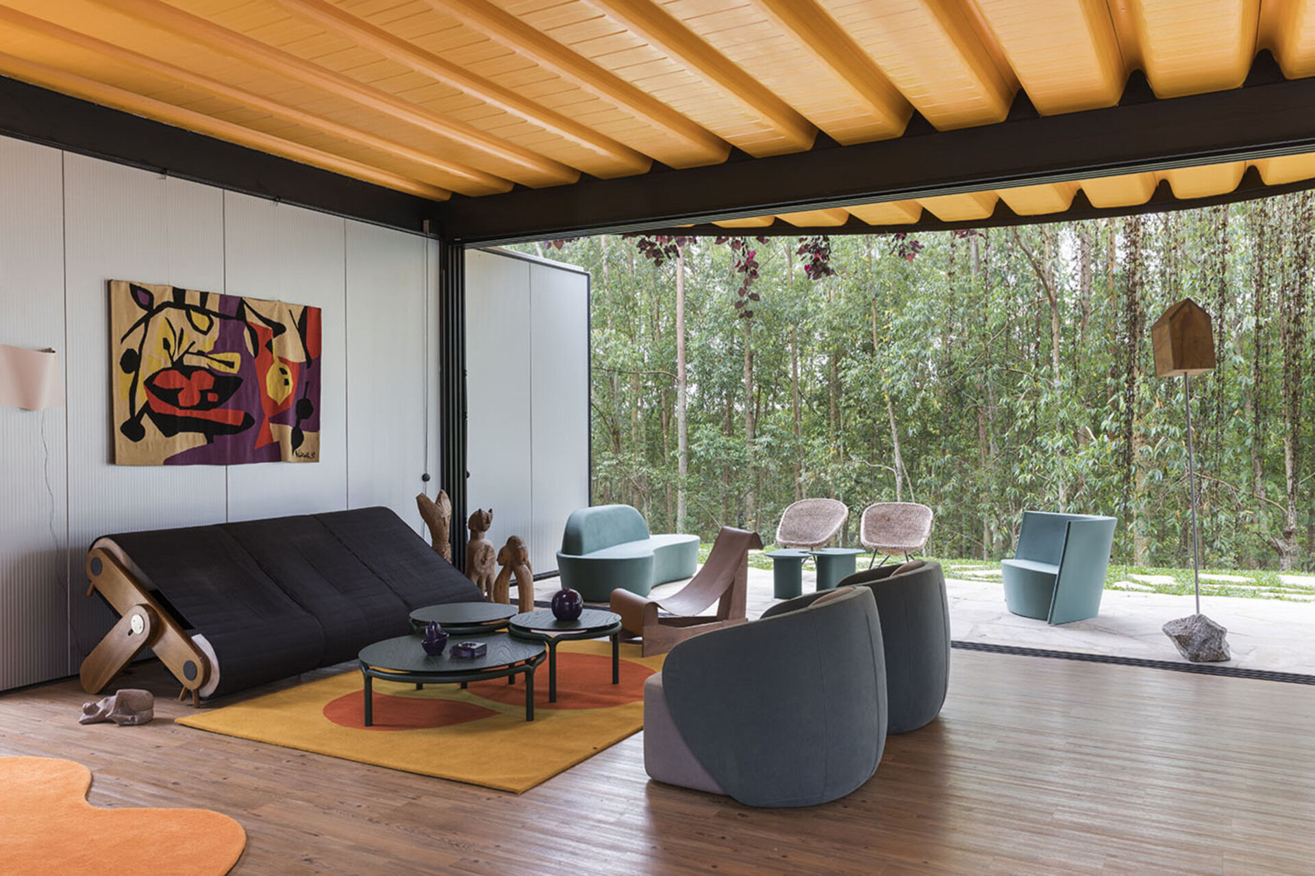 Orange accents, custom furniture, and curtainless windows define the interiors of this joyful weekend home. Everything is designed to feel open, natural, and full of life.
