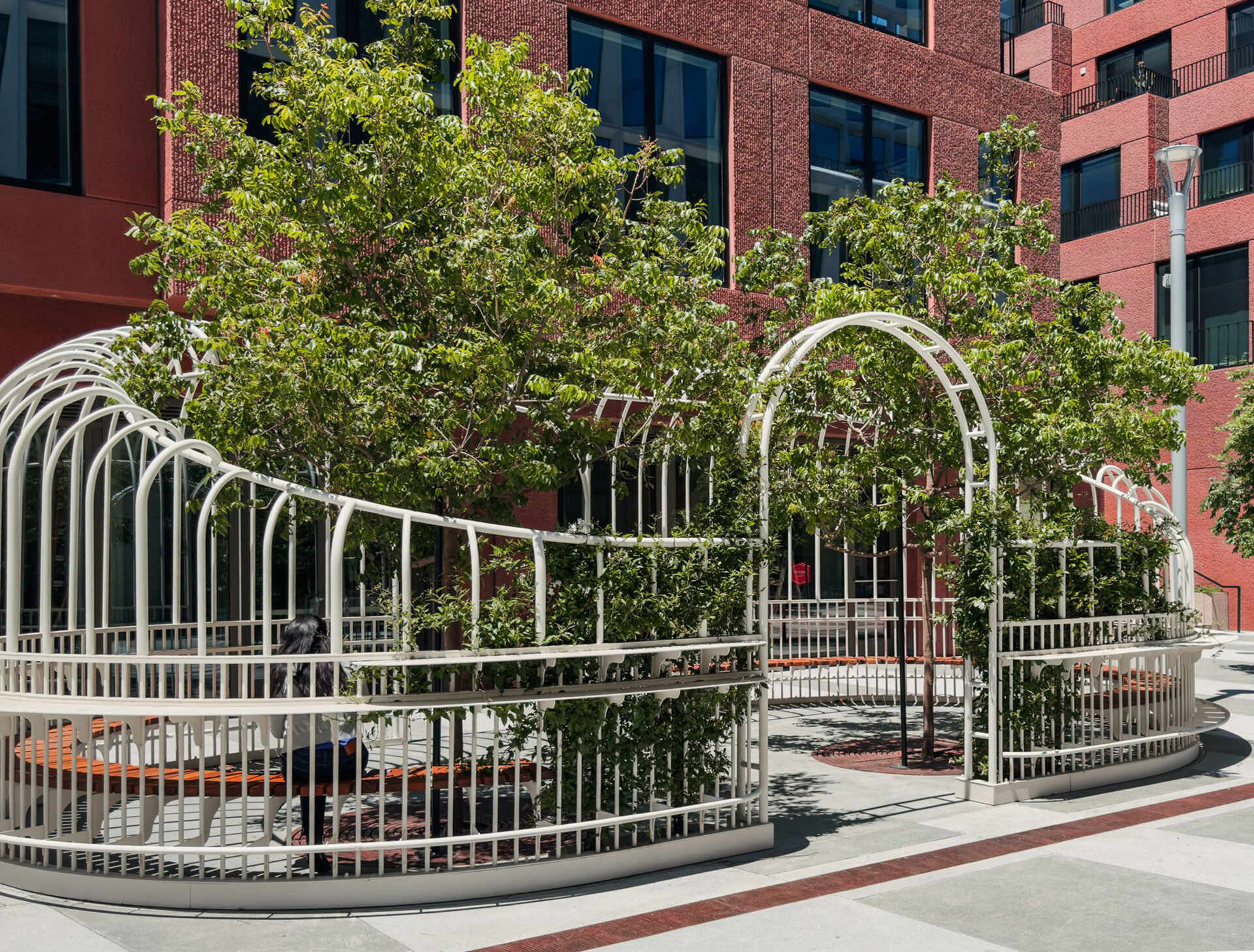 A serene urban pavilion in San Francisco’s Mission Rock, The Garden Party by Min Design reinterprets the Victorian greenhouse as a light-filled public space. With its curving form, custom detailing, and living canopy of integrated trees, this open-air installation invites pedestrians to pause, connect, and enjoy a moment of calm in the city.