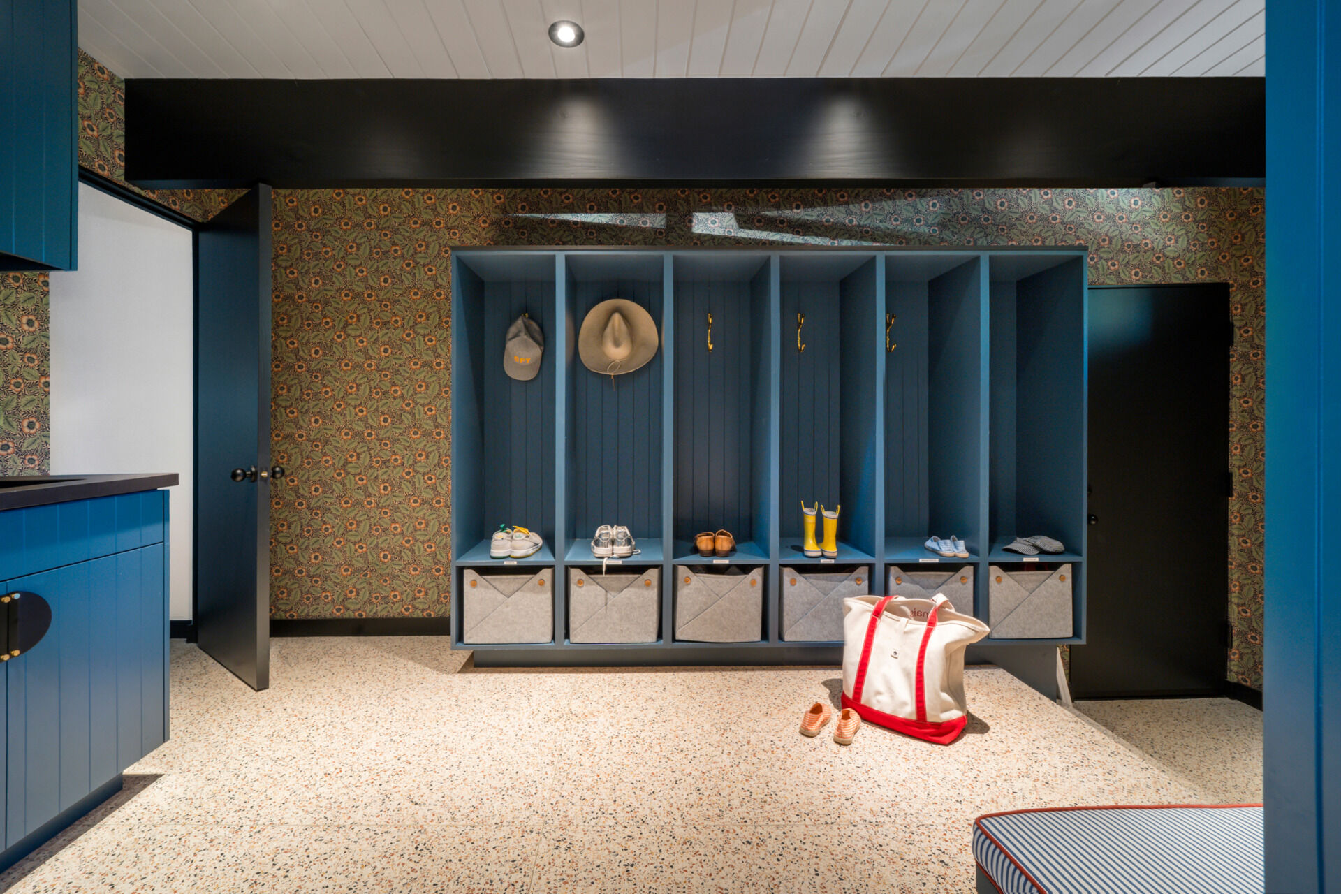 Near the entrance, a thoughtfully designed mudroom with blue cabinetry has individual storage for each family member.