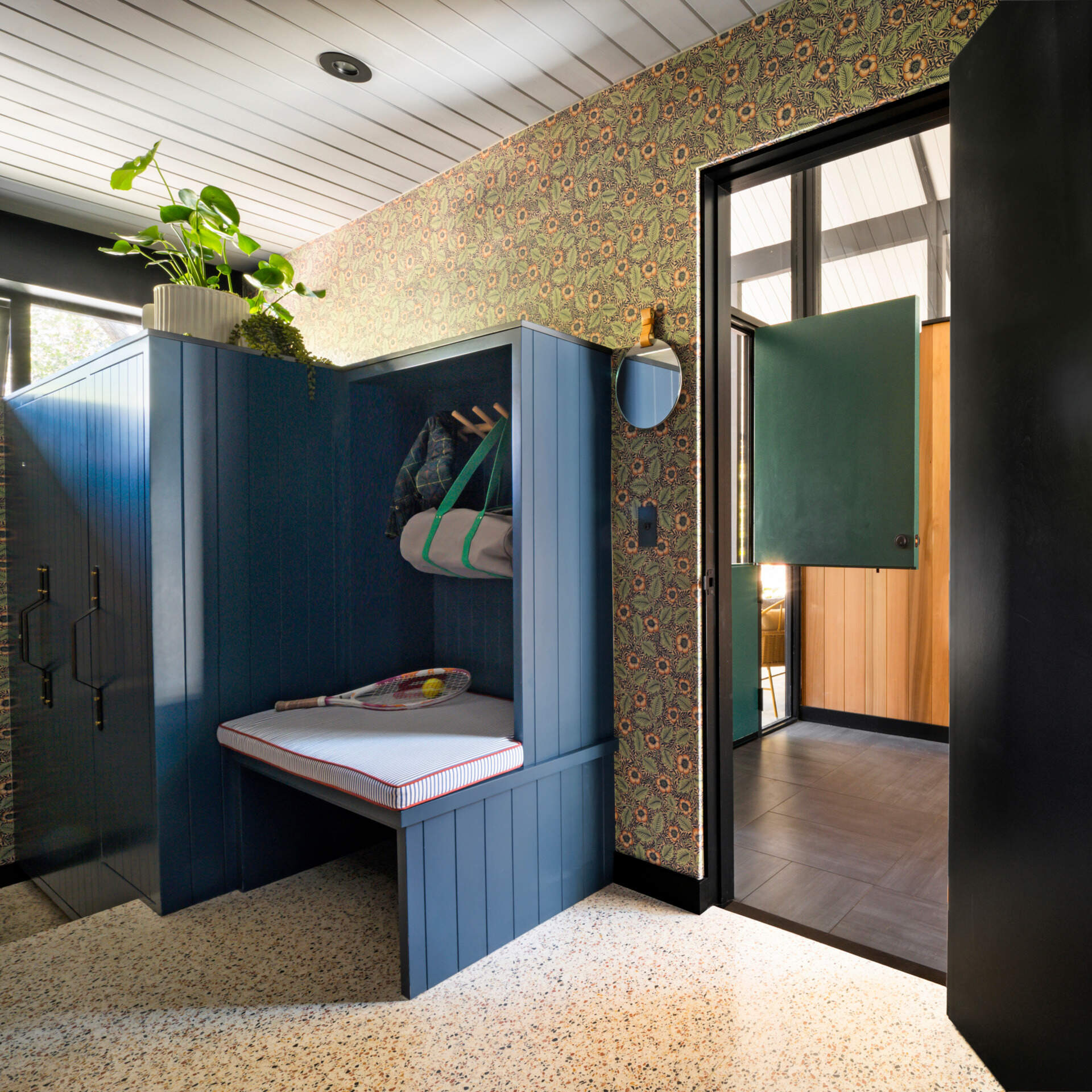 Near the entrance, a thoughtfully designed mudroom with blue cabinetry has individual storage for each family member.