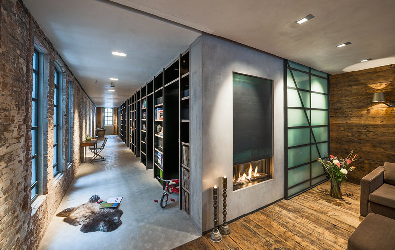 A 52-foot-long plywood bookshelf lines the hallway, concealing bedroom doors and even a bathtub—functional, beautiful, and full of surprises.