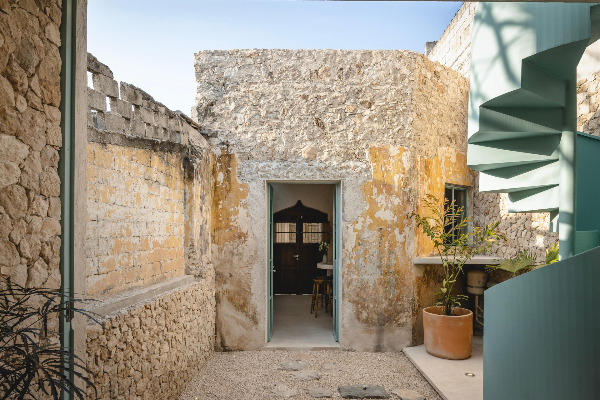 This renovated home sits on a narrow urban lot just five meters wide and over 30 meters long, and has six modules with three enclosed spaces and three open-air patios.