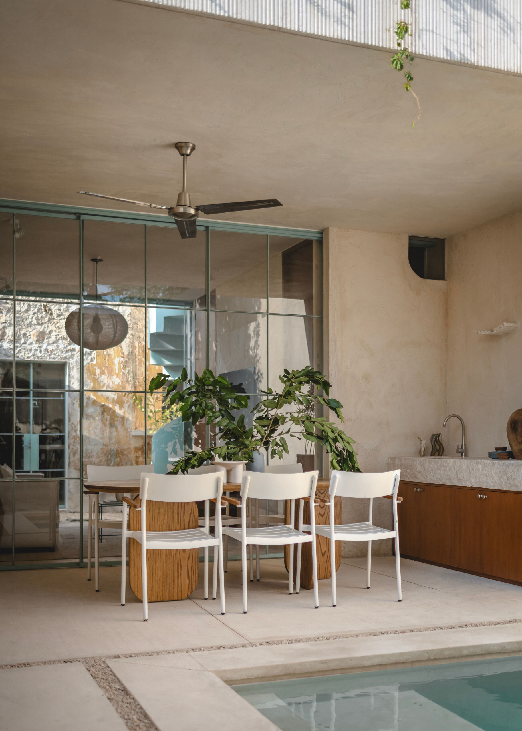 The living room and dining area benefits from the home’s layered layout. Whether placed beside the kitchen or in the patio itself, relaxing and meals unfold in a space that feels both intimate and connected to the outdoors. Minimal furnishings and subtle textures keep the focus on comfort, light, and air movement.