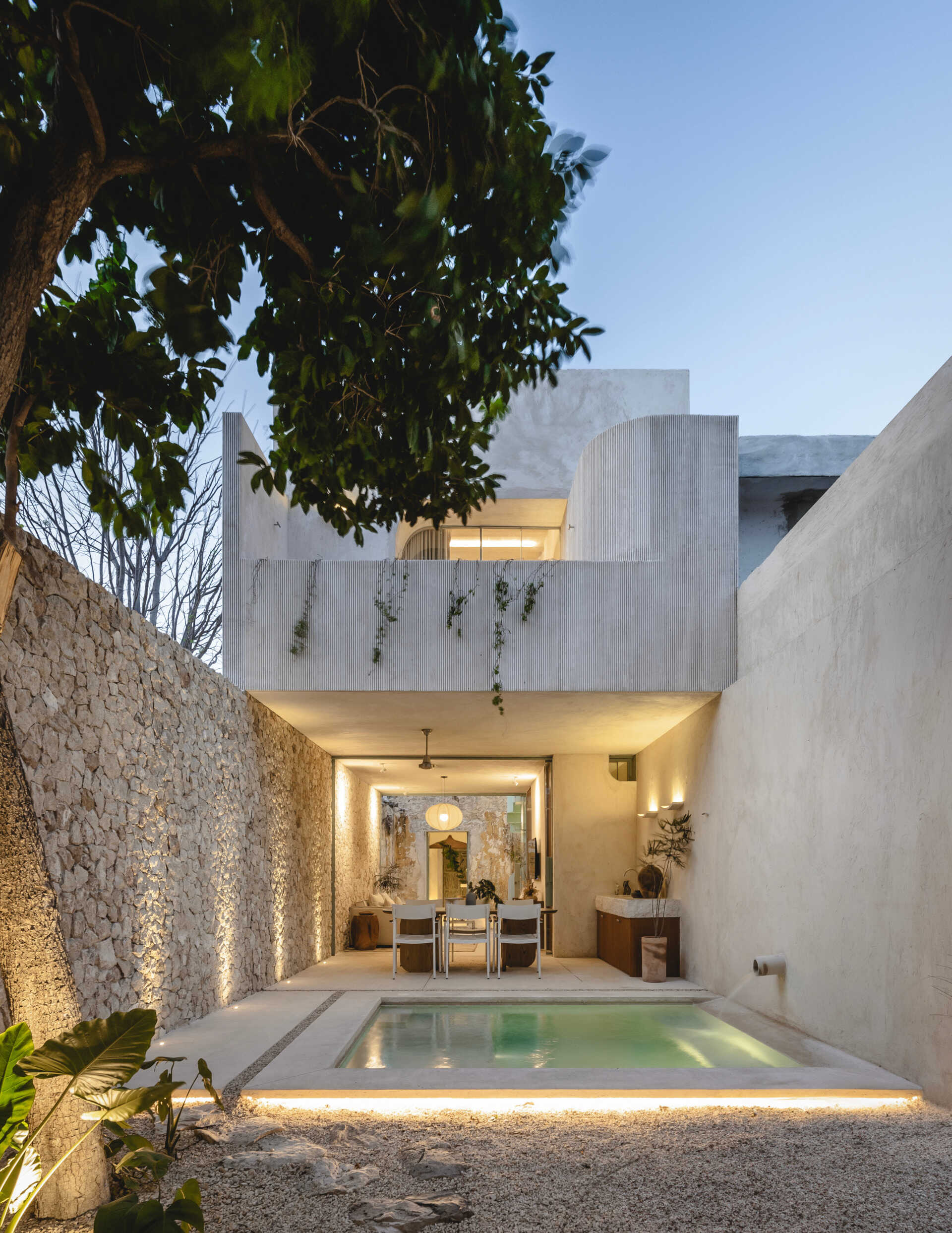Tucked into the rear garden, the pool offers a cool, shaded retreat. Its placement at the end of the spatial sequence creates a sense of discovery, and its simple geometry mirrors the clean lines of the architecture. Surrounded by regional stone and soft landscaping, the pool blends into its setting while offering visual contrast and a place to unwind.