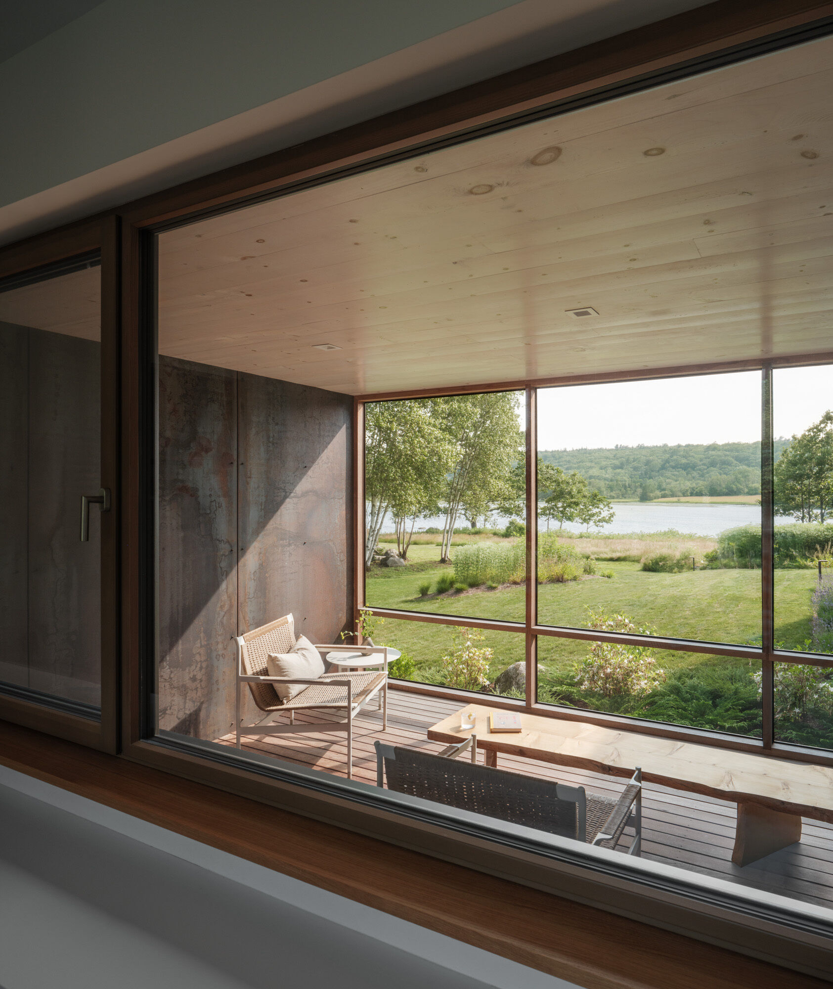 This screened porch connects the workshop to the main home, and offers views of both the entry path and the river beyond. Designed for lingering.