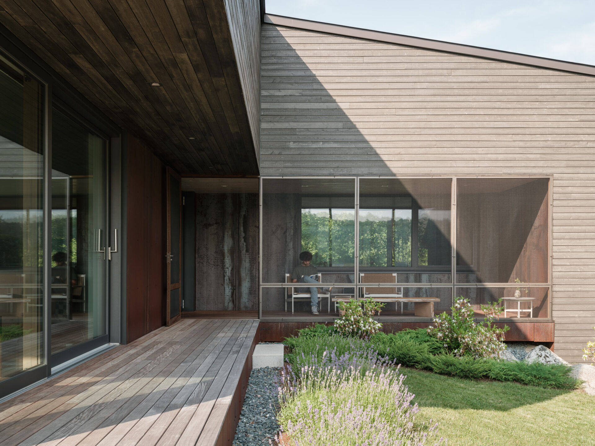 This screened porch connects the workshop to the main home, and offers views of both the entry path and the river beyond. Designed for lingering.