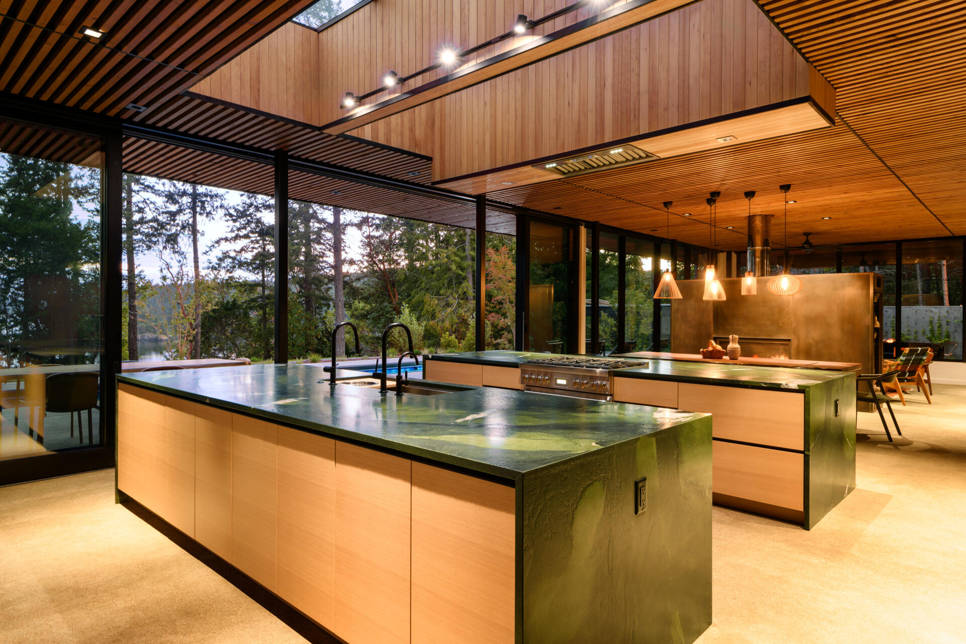 An open plan kitchen with two islands and skylights, is built for gathering, with clean lines, ample light, and strong indoor-outdoor flow.