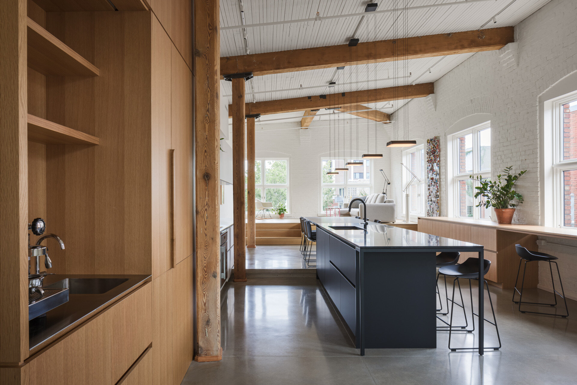 A split-level living room with views of Mont Royal, custom millwork, and a hidden guest bed. This space blends comfort, clever design, and elevated simplicity.