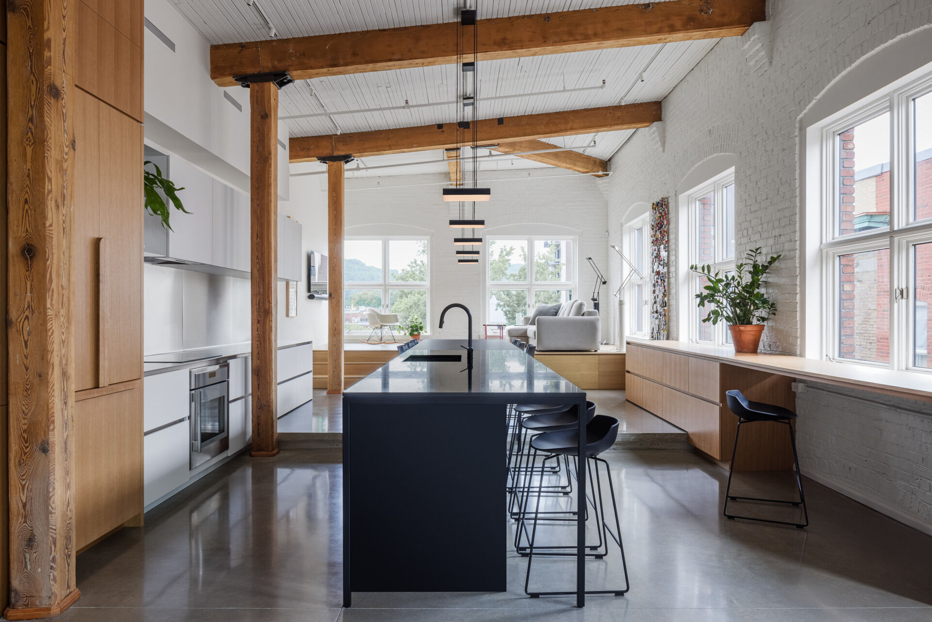 A split-level living room with views of Mont Royal, custom millwork, and a hidden guest bed. This space blends comfort, clever design, and elevated simplicity.