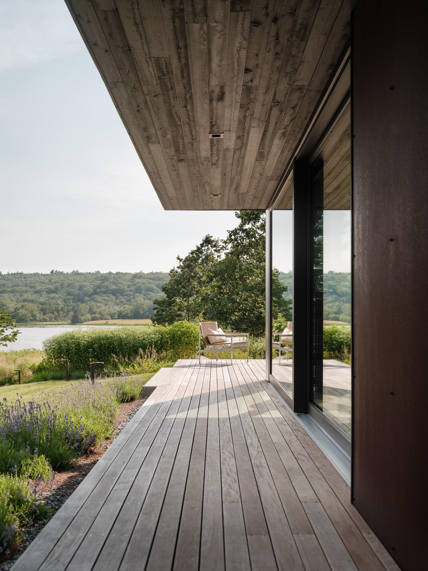 This screened porch connects the workshop to the main home, and offers views of both the entry path and the river beyond. Designed for lingering.