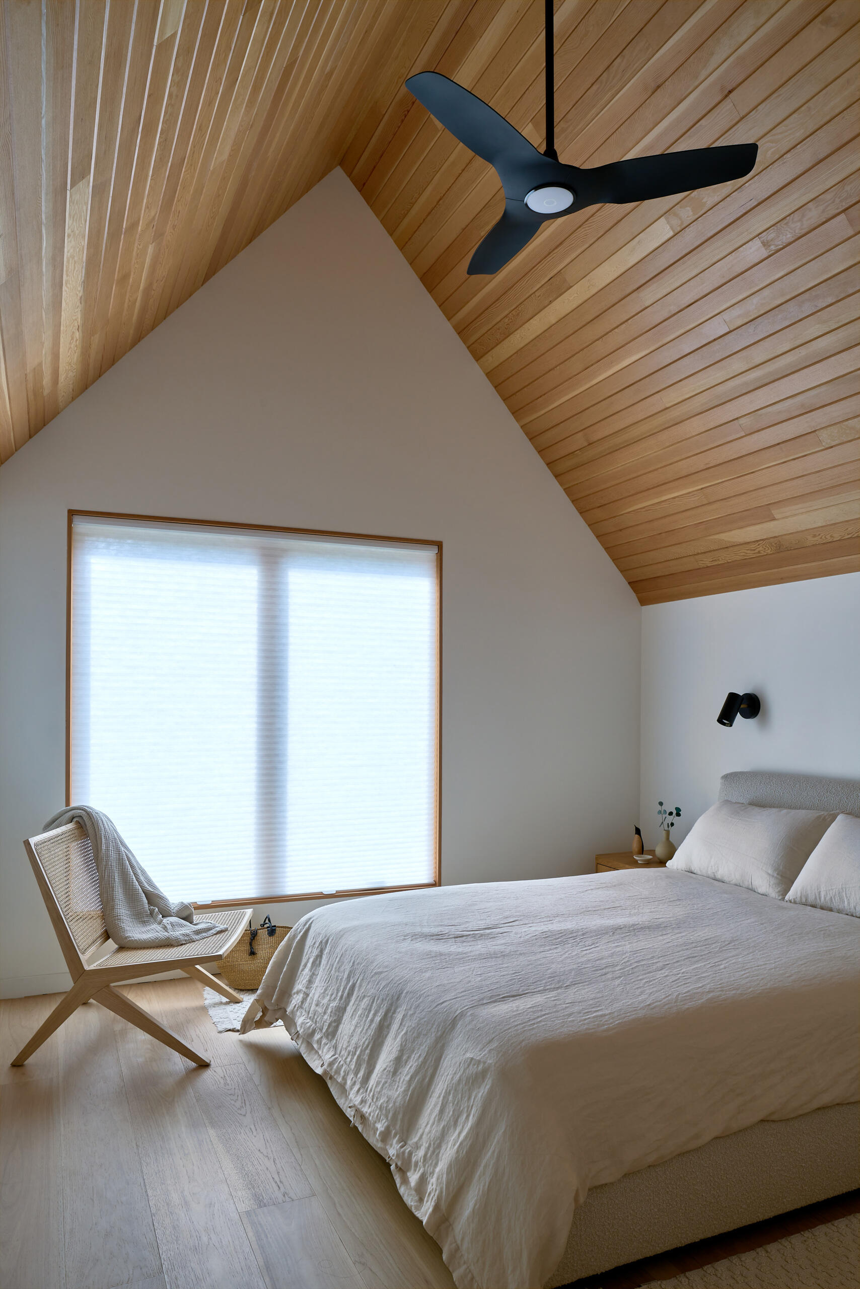 The primary bedroom, with its wood-lined vaulted ceiling, is positioned for privacy, offering a quiet sanctuary within the home.