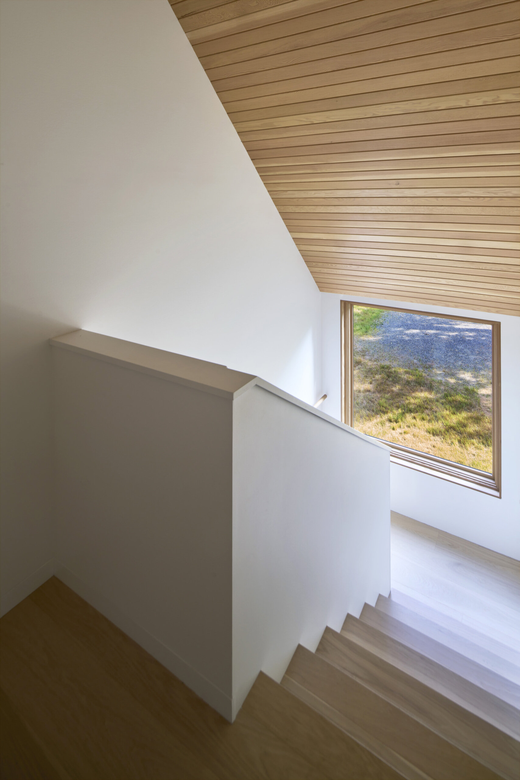 Wood stairs provide a transition between levels, reflecting the cabin’s clean-lined design while maintaining the natural warmth of the material palette.