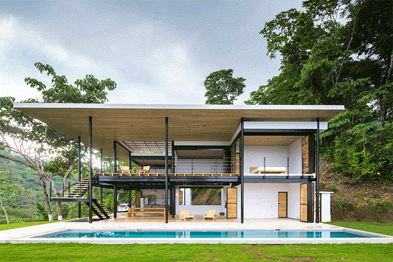 This modern home unfolds through interwoven terraces that step and layer across multiple levels, framing views of both treetops and ocean horizons, while movable wood walls fold away, creating open living spaces.