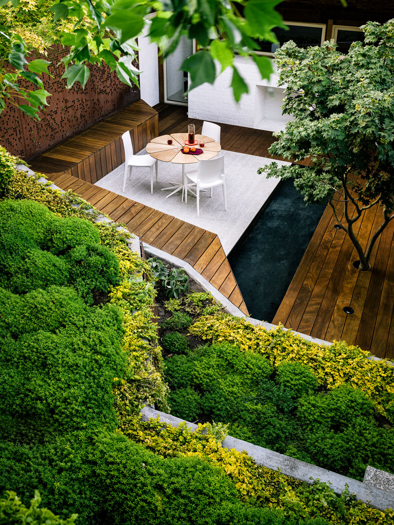 A narrow, sloped backyard is transformed into a Zen-like garden retreat with a winding ramp, concrete terraces, and layered plantings. It also features a reflecting pool, Japanese maples, and panoramic views.