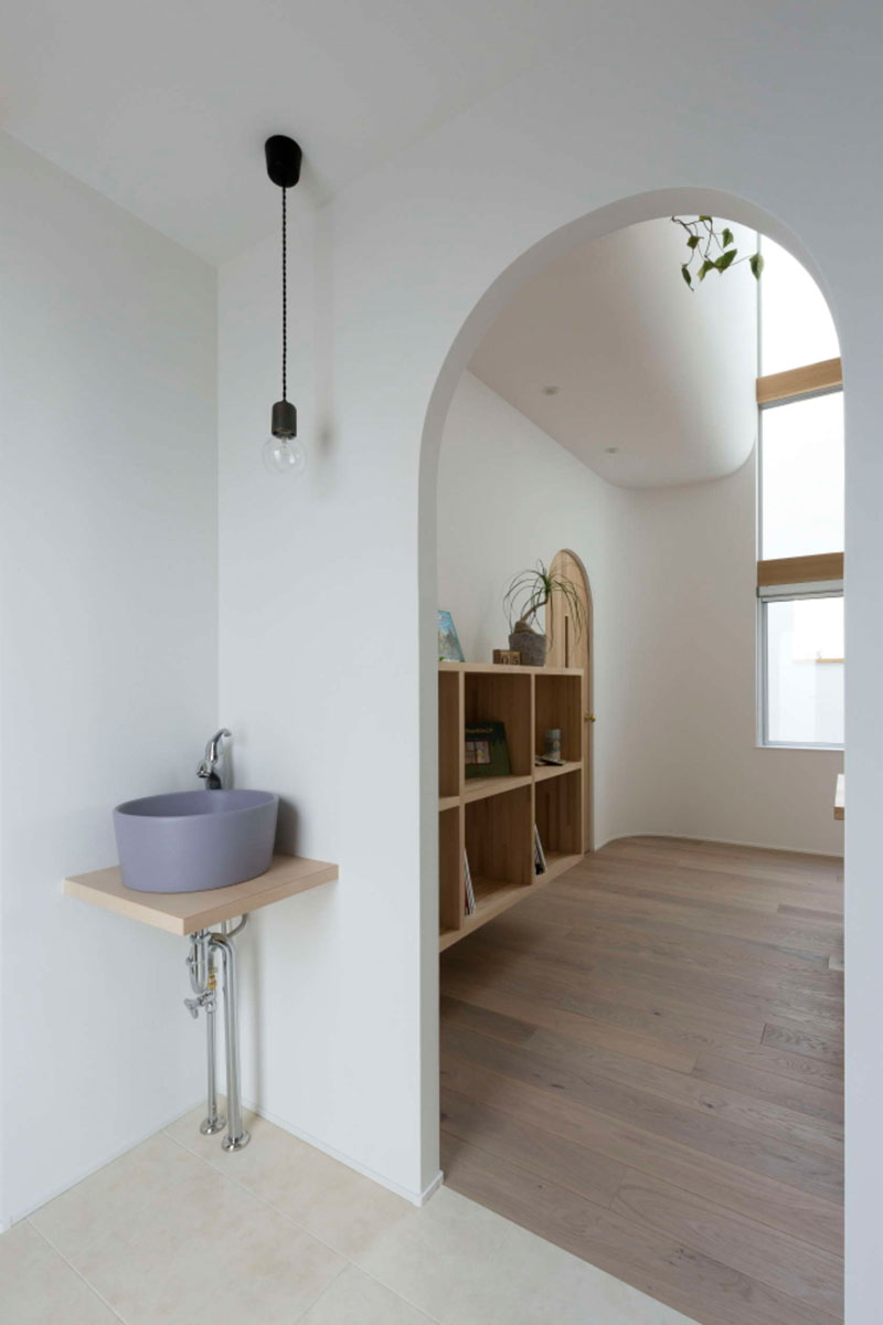 A warm and inviting Japanese home featuring beautiful arched doorways, soft natural light, and a simple wood-toned interior that creates a cozy and timeless atmosphere.