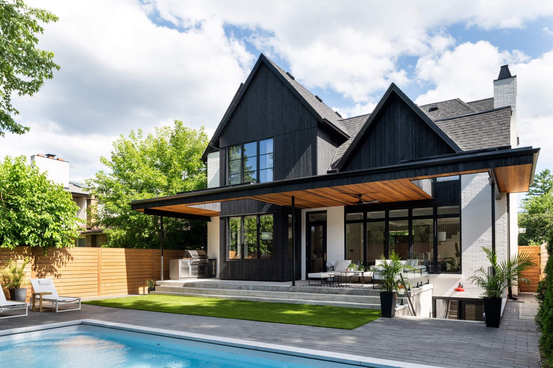 The rear of this home unfolds into a partially covered patio. A thoughtful roof cutout allows daylight to filter deep inside, creating an effortless flow between house and garden. Designed as an outdoor living room, this space extends the home’s social and family-centered atmosphere.