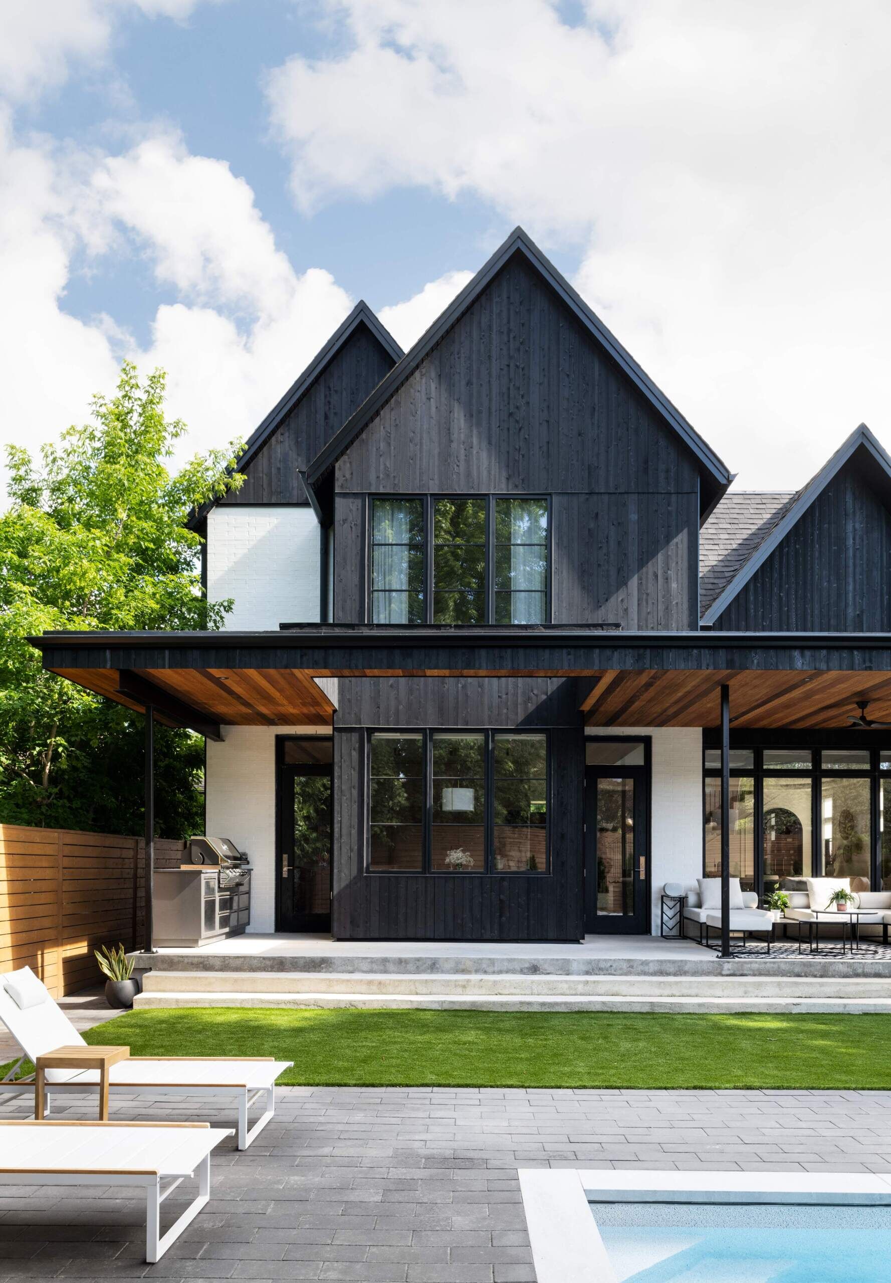 The rear of this home unfolds into a partially covered patio. A thoughtful roof cutout allows daylight to filter deep inside, creating an effortless flow between house and garden. Designed as an outdoor living room, this space extends the home’s social and family-centered atmosphere.