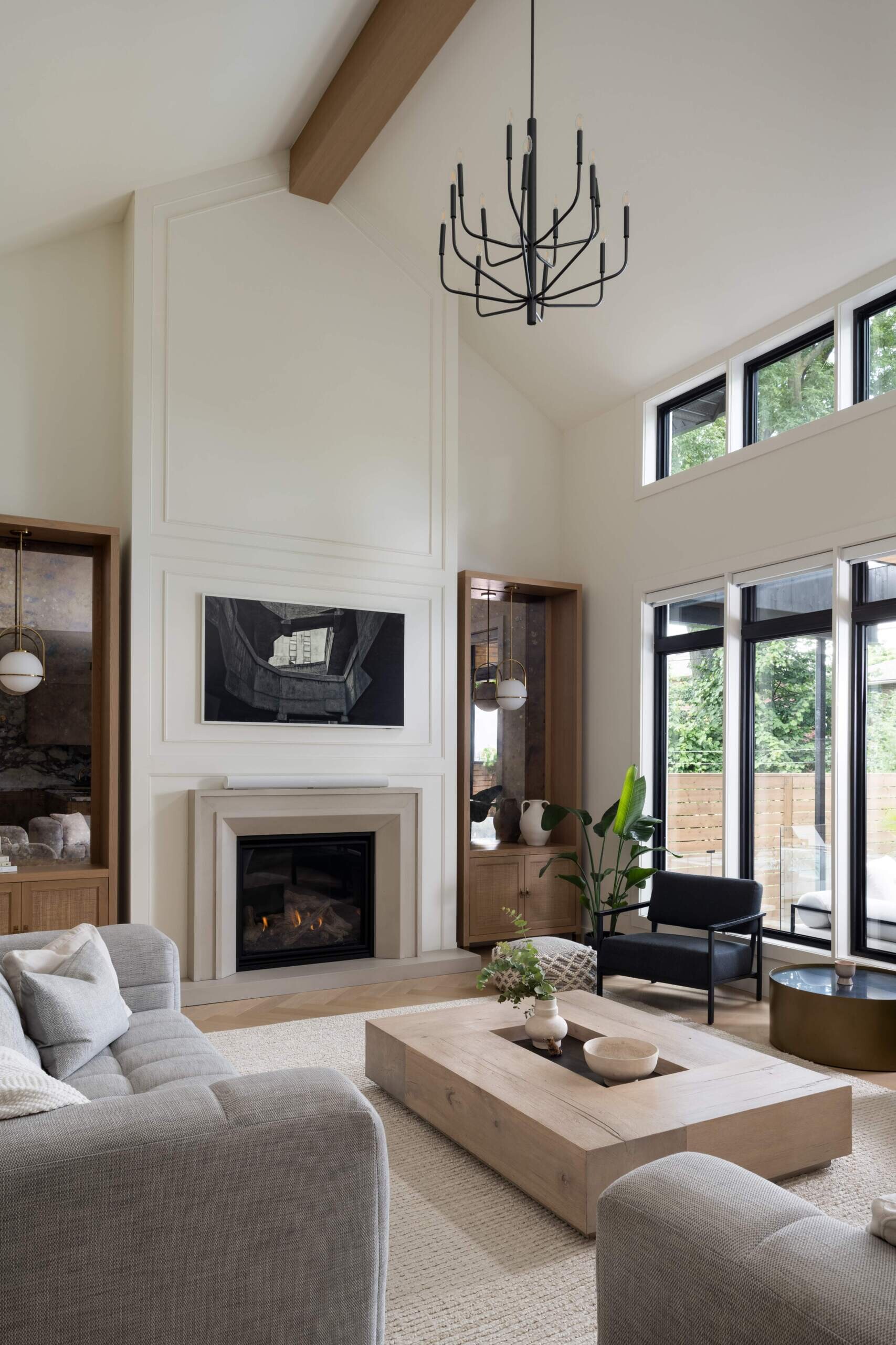 This living room is shaped by sculpted ceilings that lend quiet drama to the open-plan layout. The restrained palette keeps the focus on natural light and proportion, setting a calm tone for family life.
