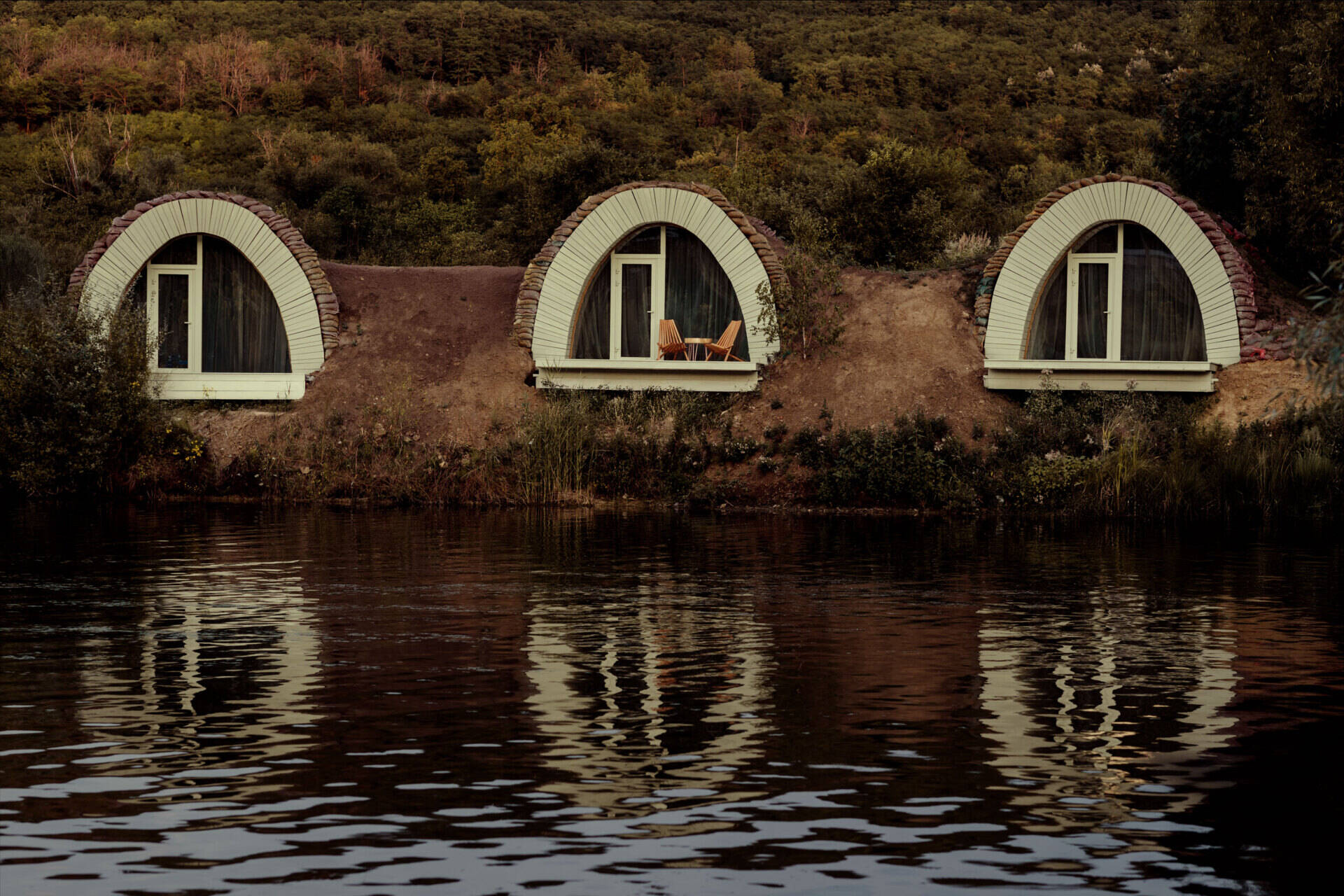 Hobbit-inspired cabins built-into the earth, includes a bedroom, kitchen, and bathroom.